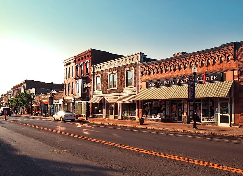 The village of Seneca Falls, New York, just before sundown, with a soft glow illuminating the historic buildings and quiet streets, reflecting the charm of this small Finger Lakes community.