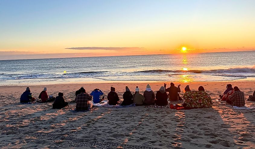 Group of friends gathering for a beach sunrise on New Year's Eve on Assateague Island, Berlin, Maryland.