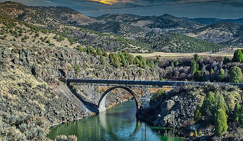 Bridge over the canal surrounded by mountains during sunset in Grace, Idaho