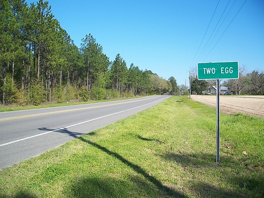 Western town limits of Two Egg, Florida, along State Road 69, marked by a roadside sign with a rural landscape in the background.