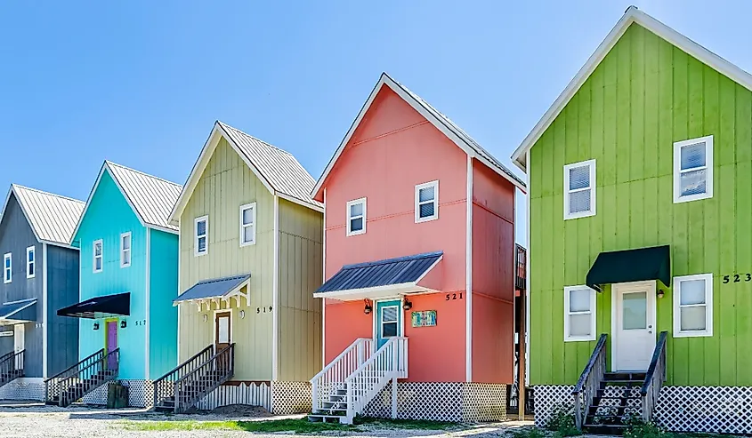 A row of colorful beach houses known as “The Birdhouses” overlook Bayou Aloe, in Dauphin Island, Alabama.