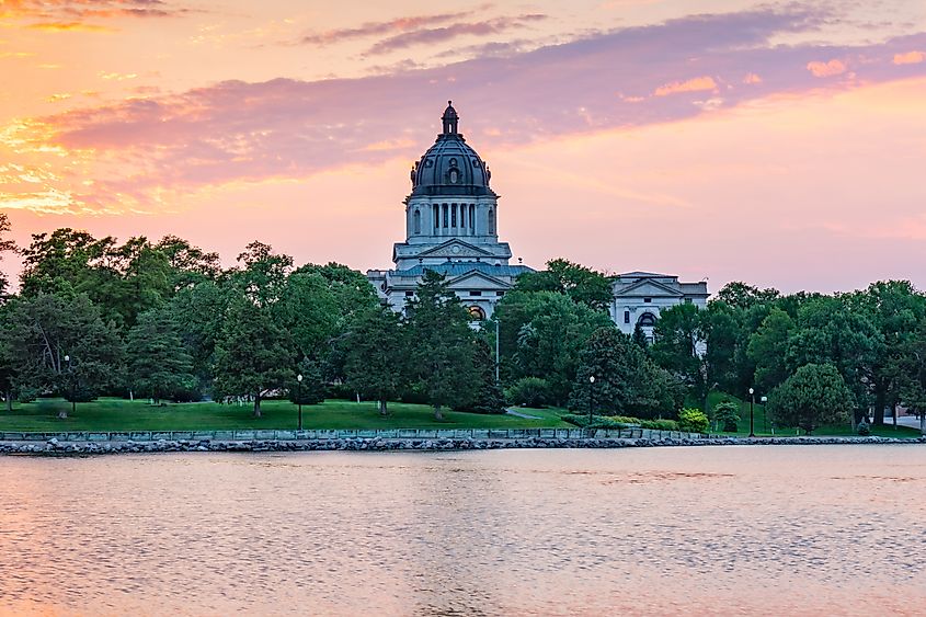 South Dakota Capital Building along Capitol Lake in Pierre, SD at sunset.