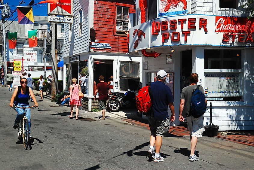 People enjoy a sunny summer vacation day walking and biking in downtown Provincetown, Massachusetts, on Cape Cod. Editorial credit: James Kirkikis / Shutterstock.com