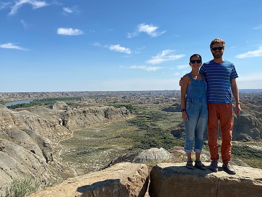 A man and a woman embrace atop a beautiful badlands viewpoint