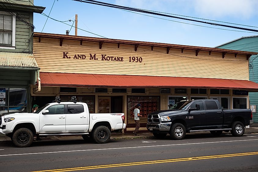 Photo of historic 1930ʻs building with man walking and parked trucks in HONOKAA, HI, U.S.A. Editorial credit: Chris Allan / Shutterstock.com