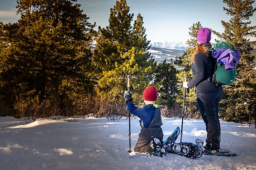 A family snowshoeing on the West Bragg Creek trail network in the Canadian Rockies near Bragg Creek, Alberta, Canada.