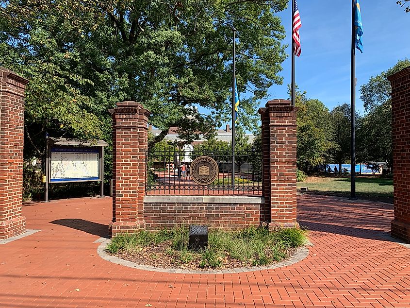 Brick columns welcome students and visitors to the University of Delaware campus on a sunny day in Newark. 