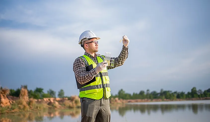 A biologist is collecting samples of water from a lake to be tested in a lab on the lake's ecosystem.