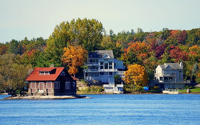 The view of waterfront homes surrounded by striking fall foliage along St Lawrence River, via Khairil Azhar Junos / Shutterstock.com