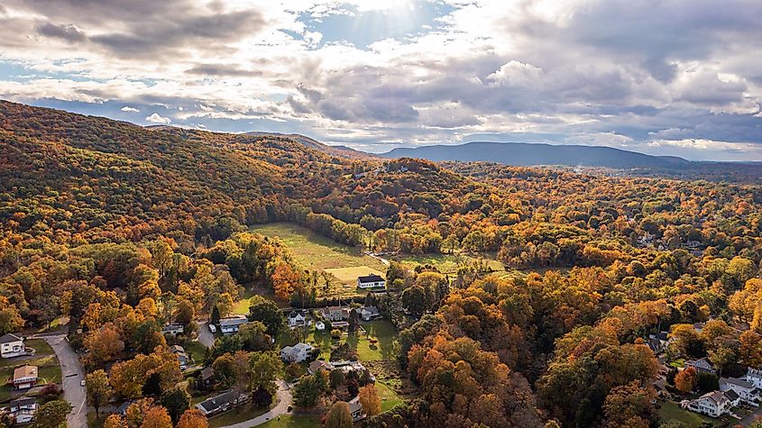 An aerial view of vibrant autumnal foliage covering a mountain in Cornwall-on-Hudson, New York