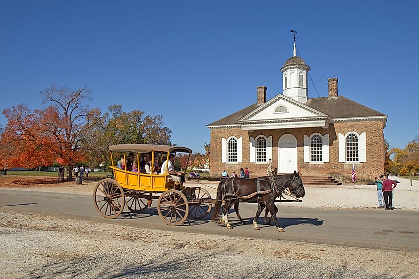 A horse-drawn carriage rides by the courthouse in Colonial Williamsburg. Editorial credit: Stephen B. Goodwin / Shutterstock.com