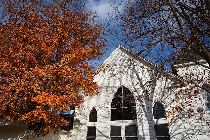 Orange autumn trees stand outside a small country church in Versailles, Missouri