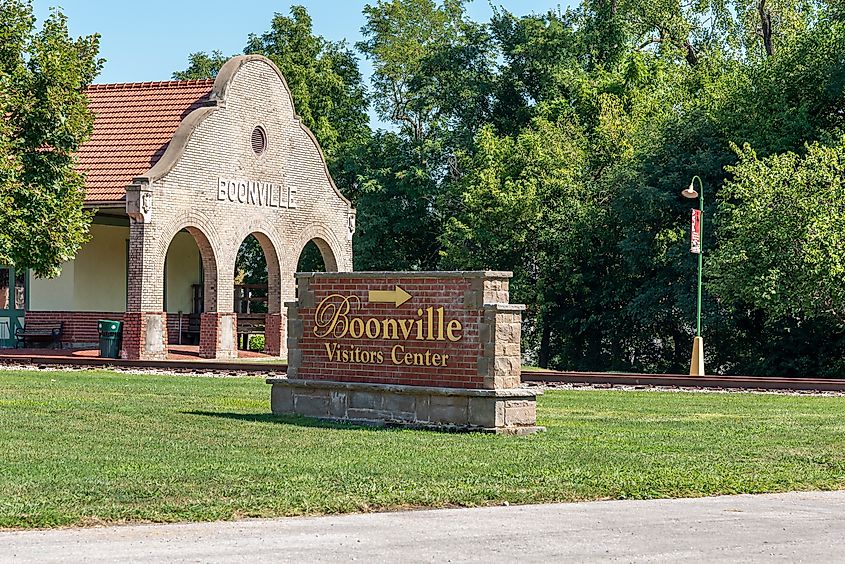  City of Boonville Visitor Center sign, with historic train depot in background.