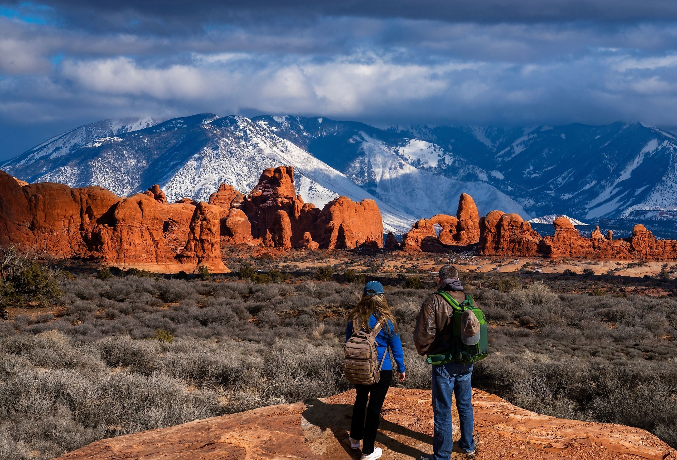 Couple in awe of La Sal Mountains at Arches National Park in Moab, Utah.