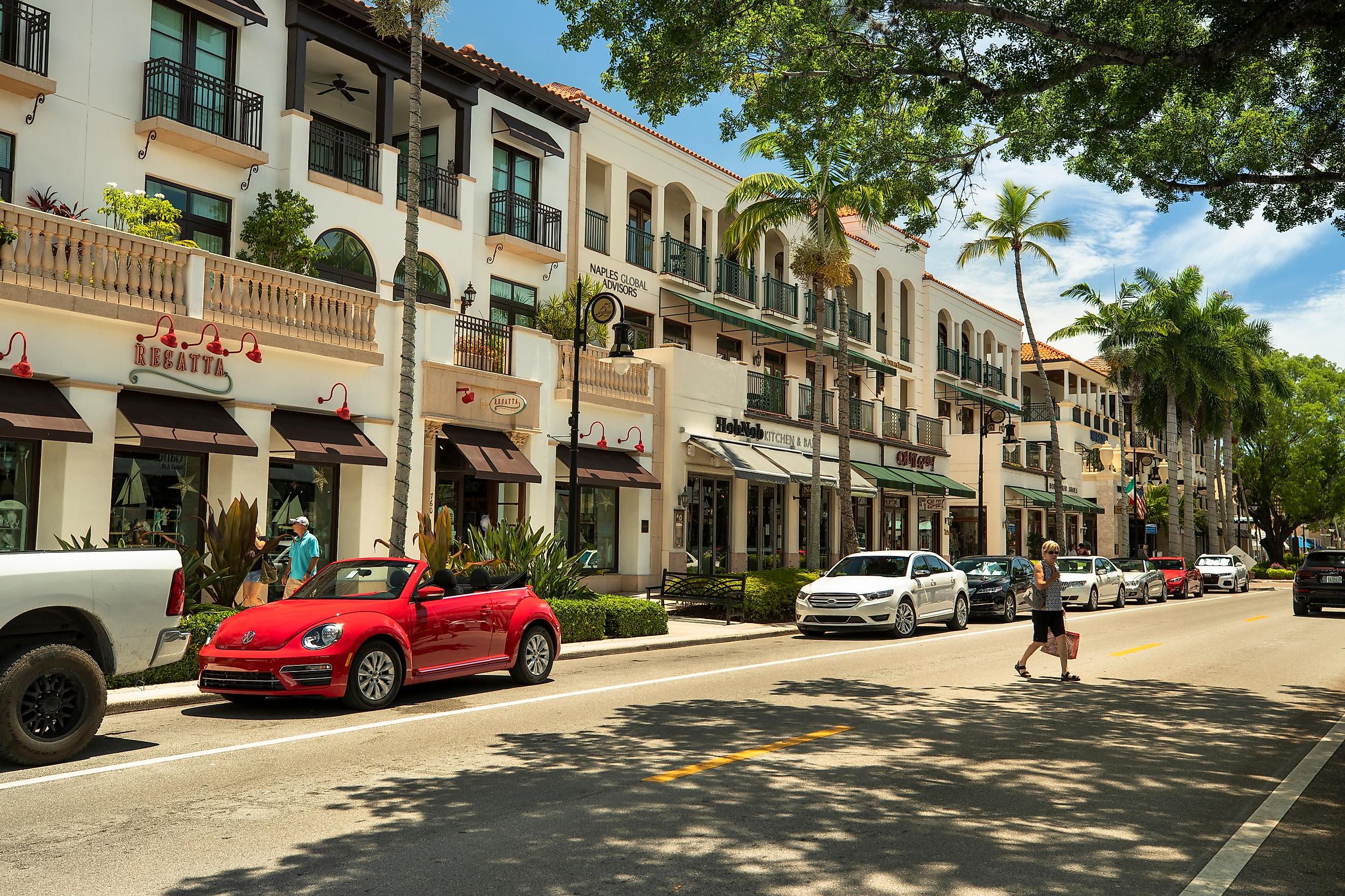 Tourists walking and shopping along the restaurants and luxury stores of 5th Avenue in downtown Naples, Florida, via AevanStock / Shutterstock.com