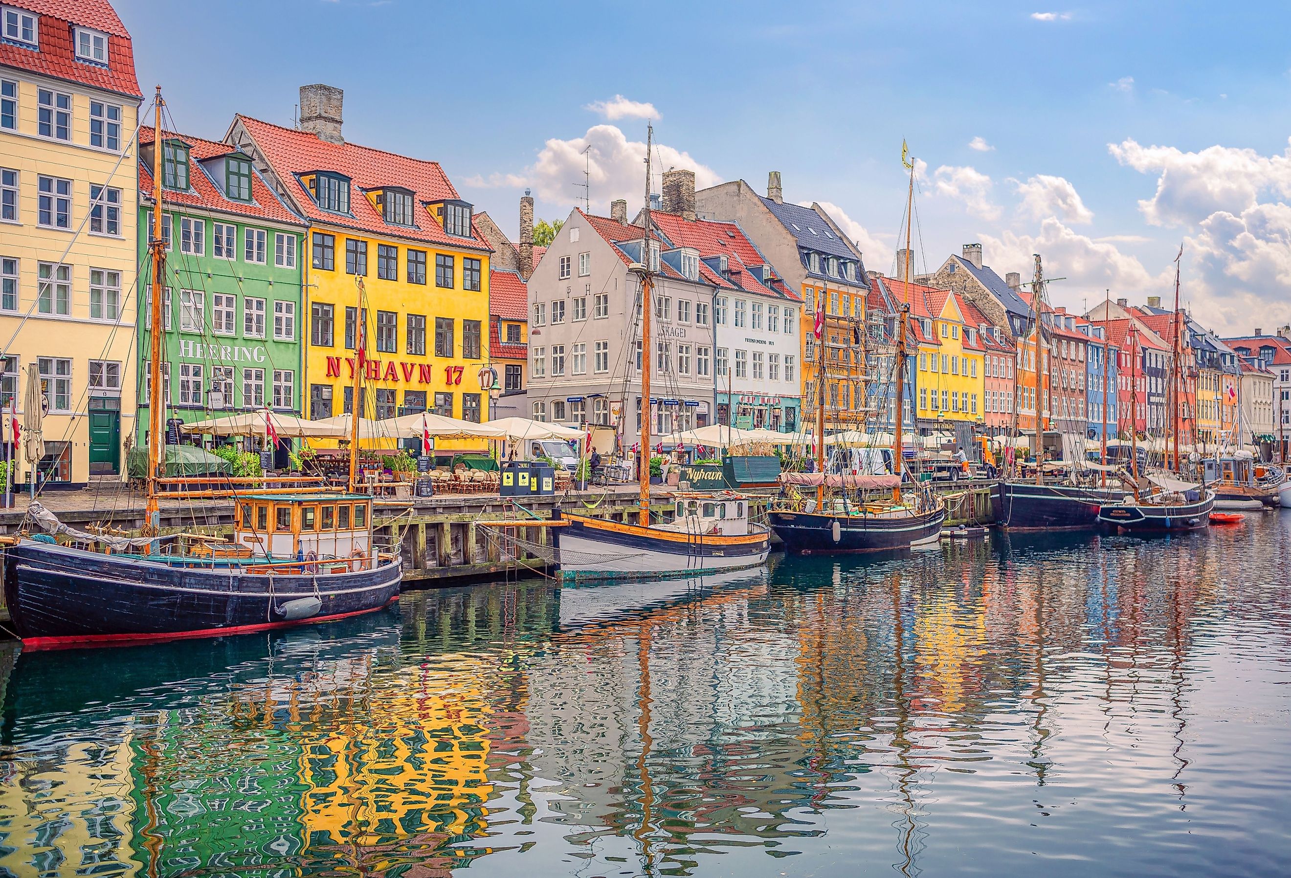 Many popular restaurants, cafes and bars in the old colorful houses on the Nyhavn waterfront in Copenhagen, Denmark. Image credit chernobrovin via Shutterstock.