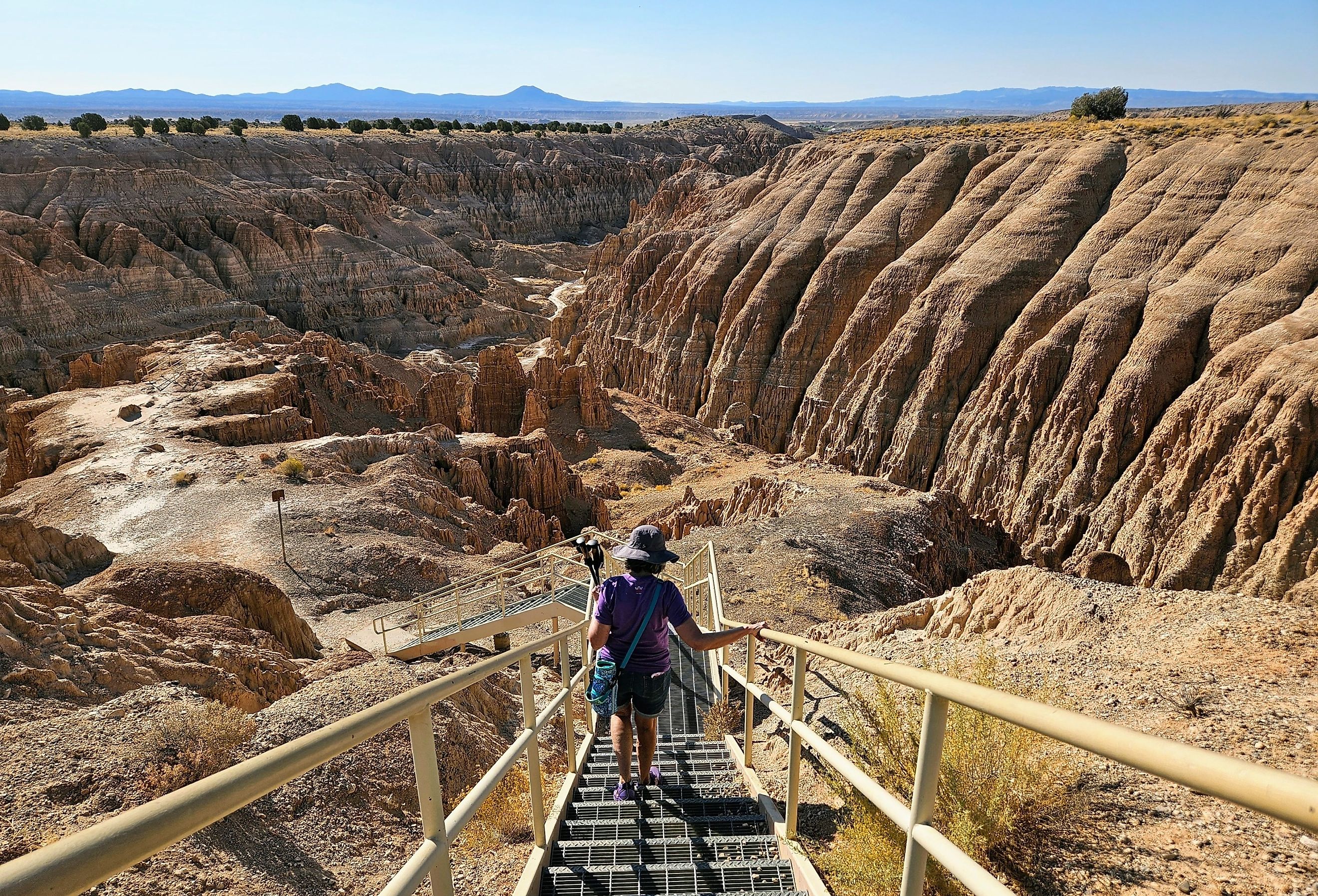 Woman hiking down a staircase into a canyon at Cathedral Gorge State Park, Panaca. Image credit nevada.claire via Shutterstock.