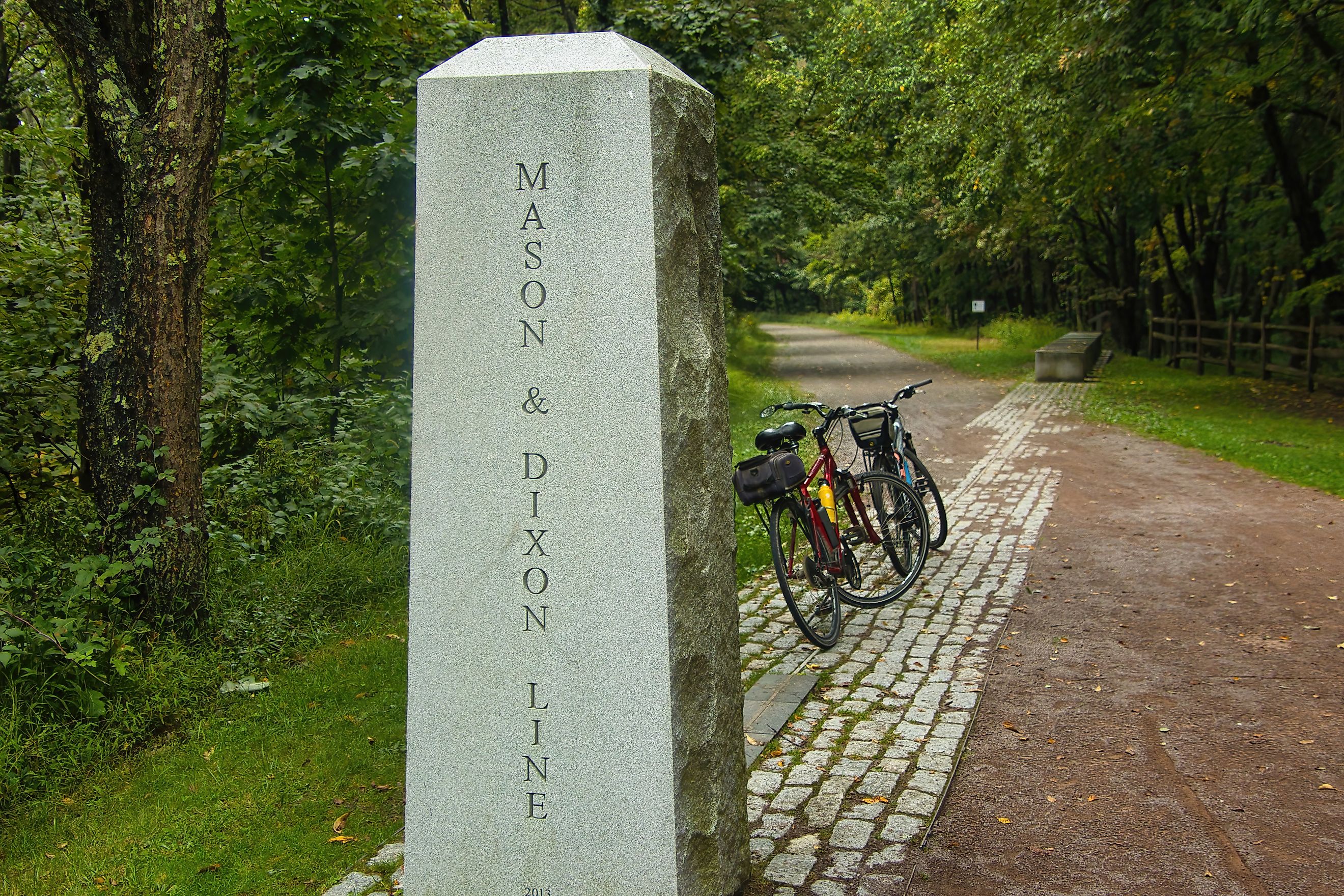 Two bikes are parked by a concrete marker indicating the location where the Great Allegheny Passage crosses the Mason Dixon Line near Frostburg, PA. Editorial credit: Dave Jonasen / Shutterstock.com