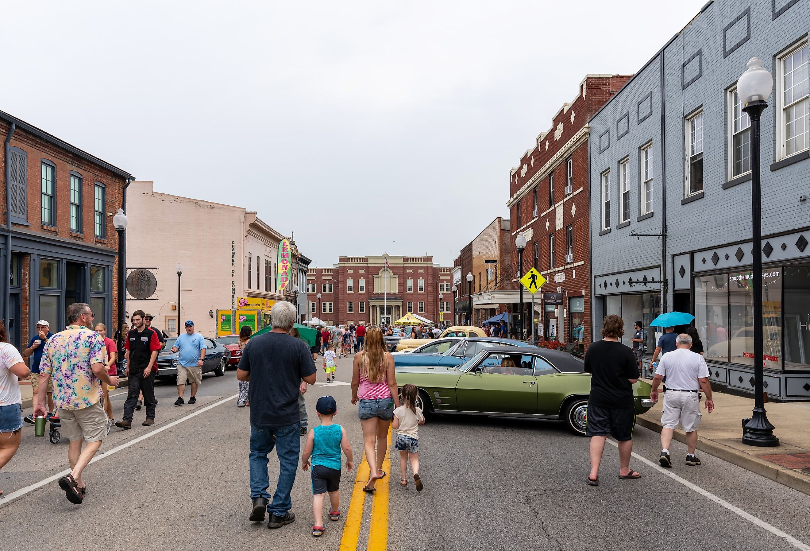 Spectators walk in the streets with cars on display during the Cruisin' The Heartland car show in downtown Elizabethtown, Kentucky. Image credit Brian Koellish via Shutterstock