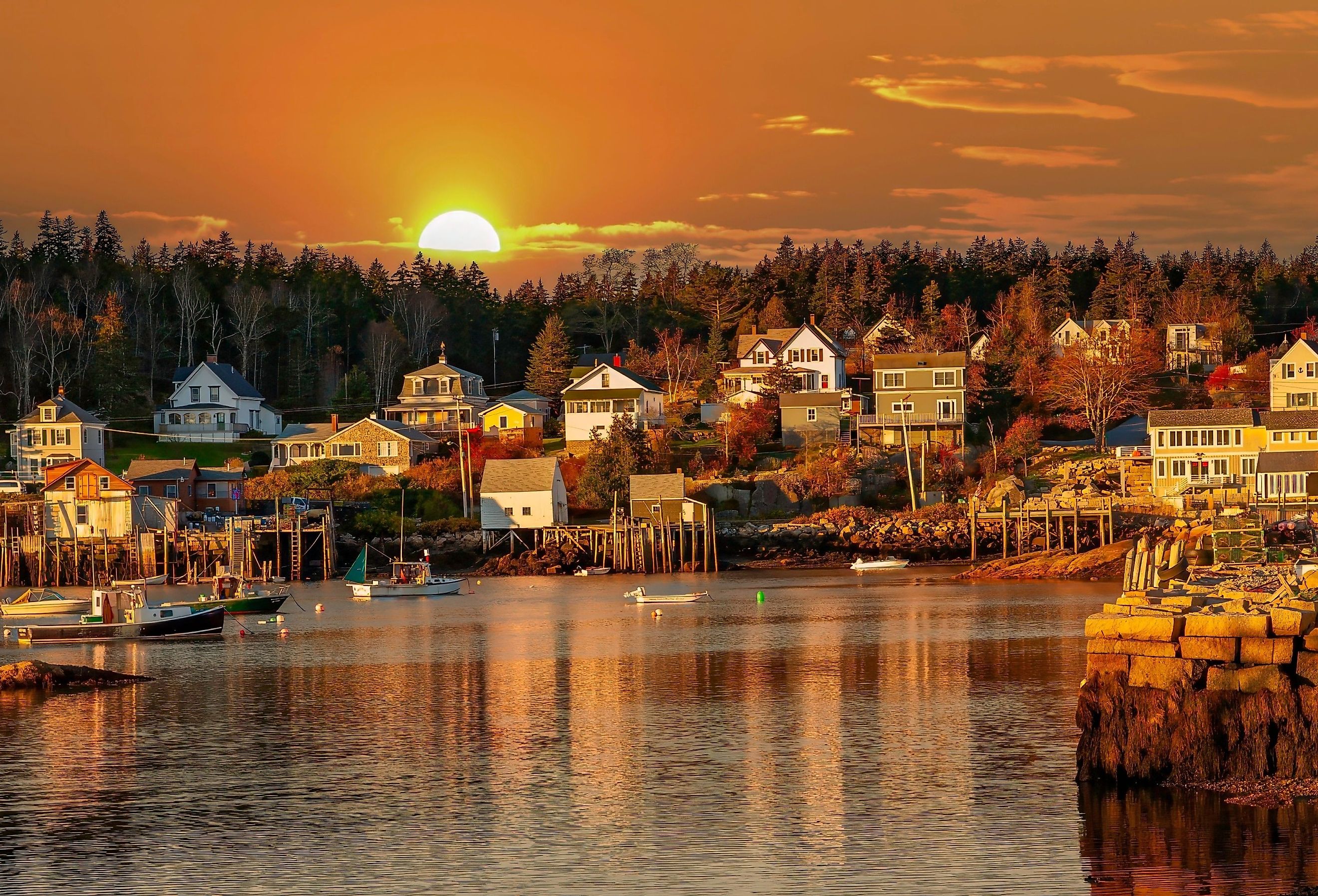 Lobster boats at anchor and bay front homes, Stonington, Maine at sunset