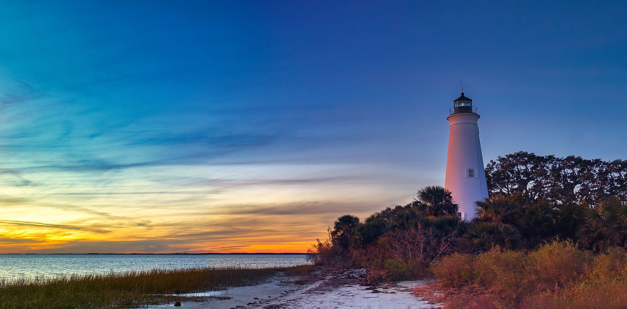 St. Marks Lighthouse at St. Marks Wildlife Refuge, silhouetted against a glowing sunset.