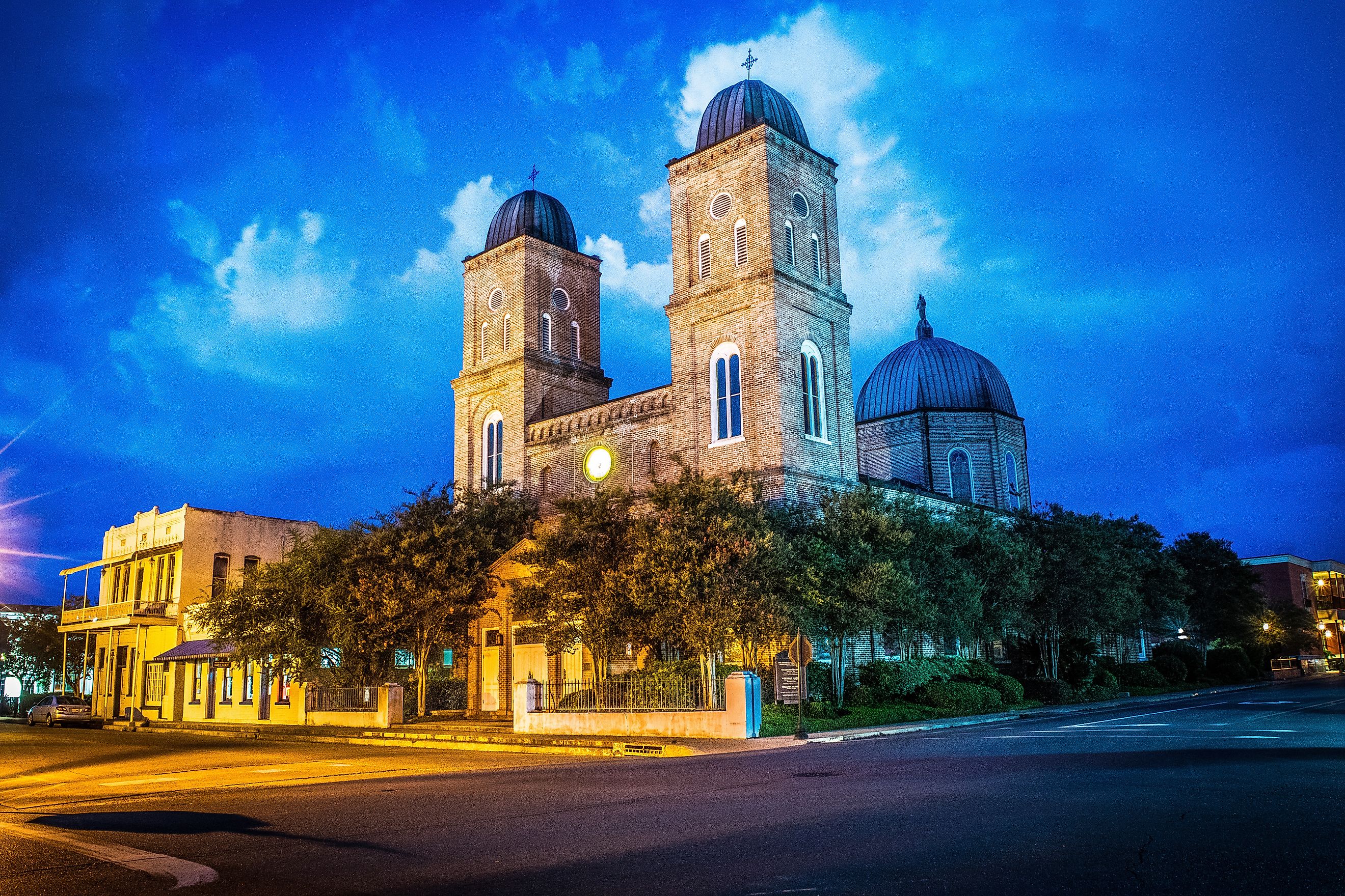 Light trails at the Minor Basilica in Natchitoches, Louisiana, creating a vibrant nighttime scene.