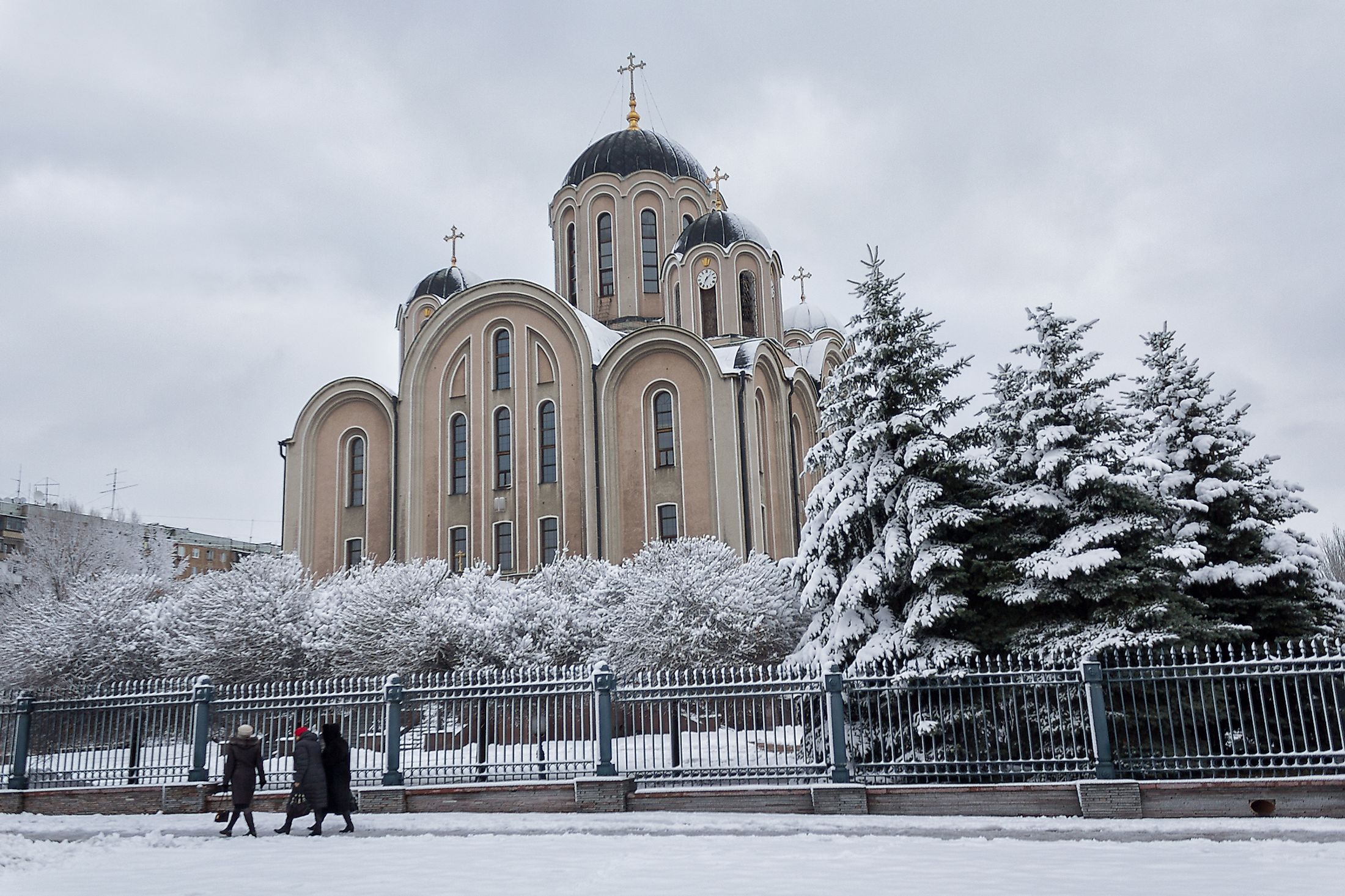 Church of the Cathedral of St. George and parishioners during winter in Makiivka, Ukraine. Editorial credit: DmyTo / Shutterstock.com