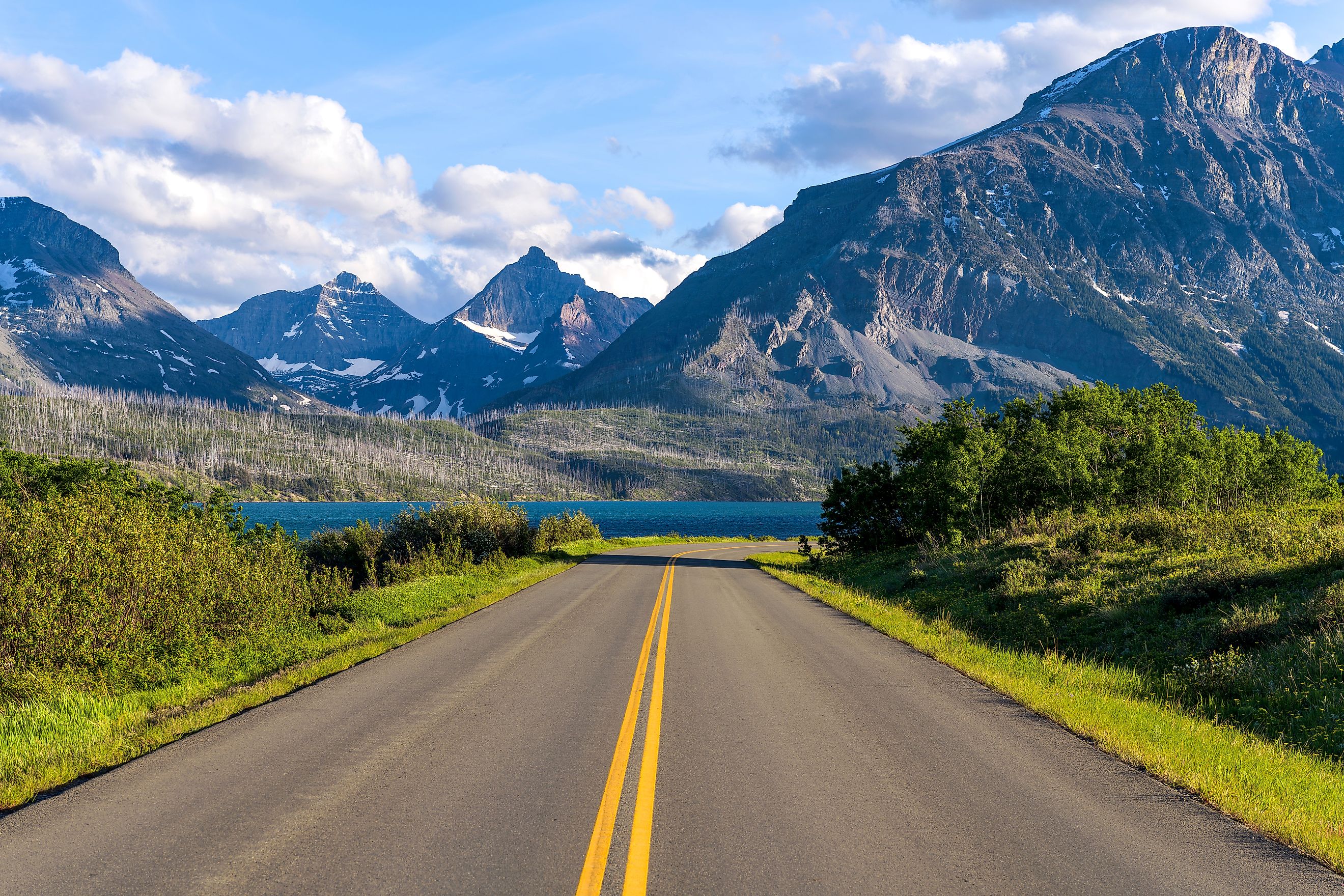 Spring evening view of the east section of Going-to-the-Sun Road at Saint Mary Lake, with rugged high peaks towering in the background, Glacier National Park, Montana, USA.