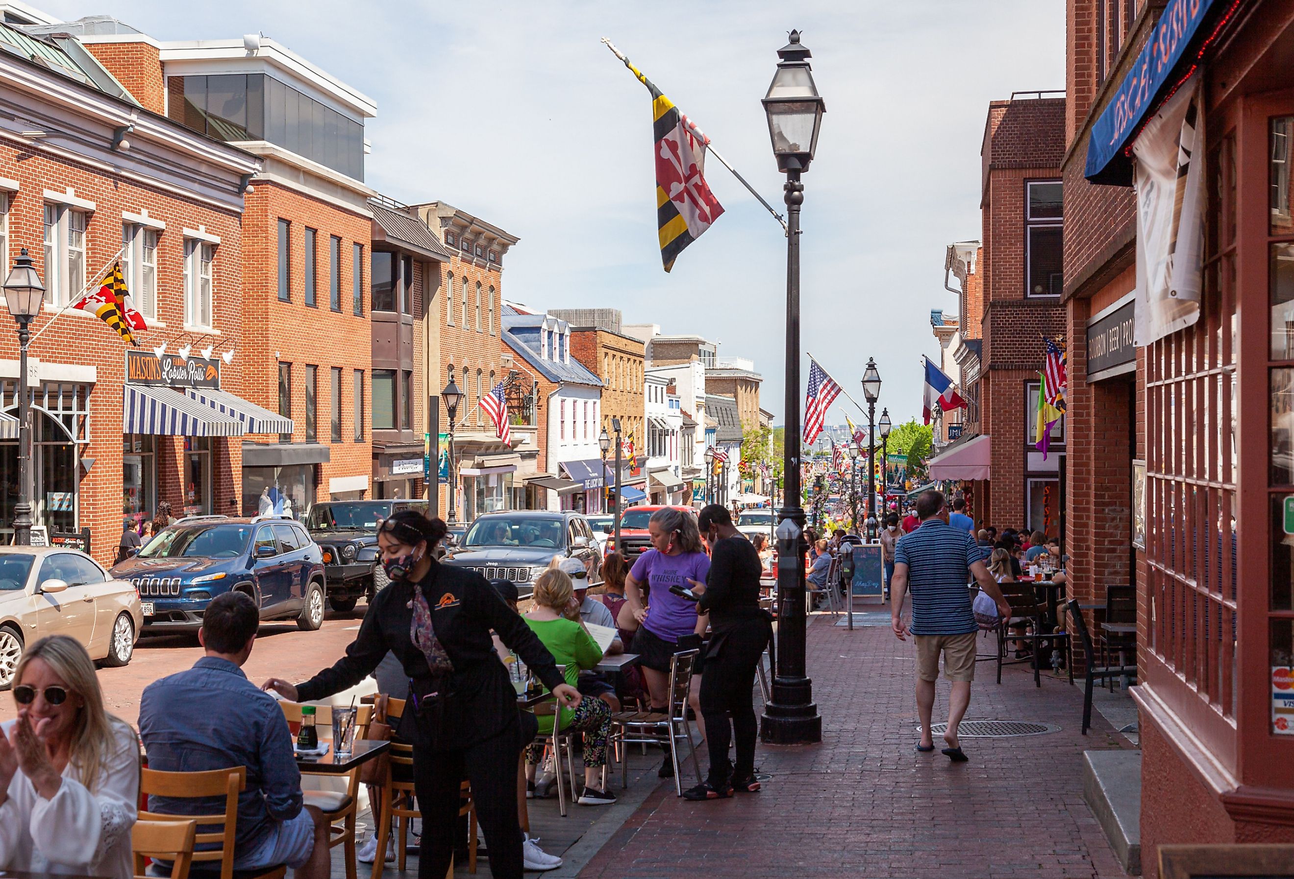 Street view of Annapolis, Maryland, with people walking in the historic town and people dining outdoors. Image credit grandbrothers via Shutterstock