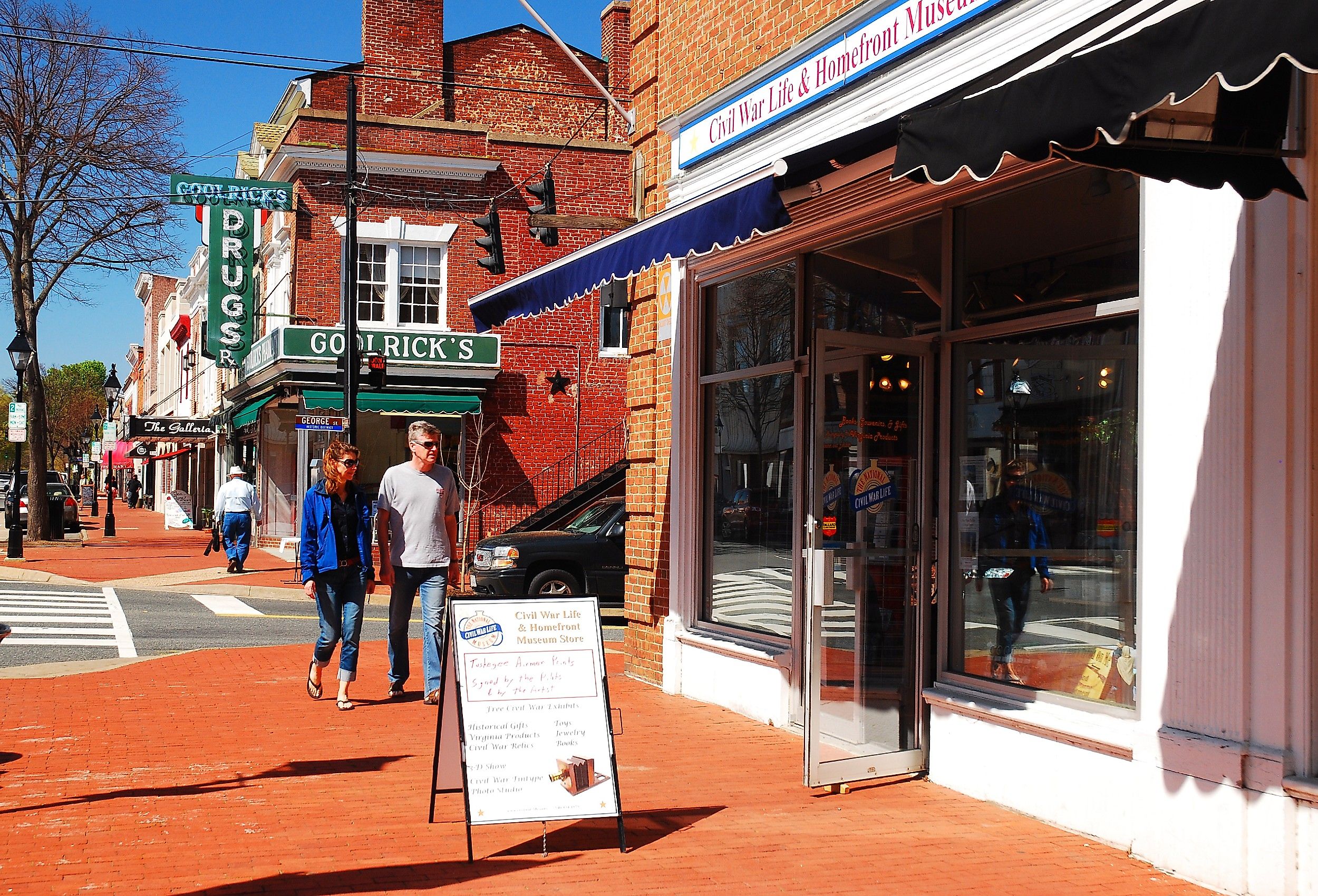 A couple walks through charming Fredericksburg, Virginia, past a Civil War Museum.