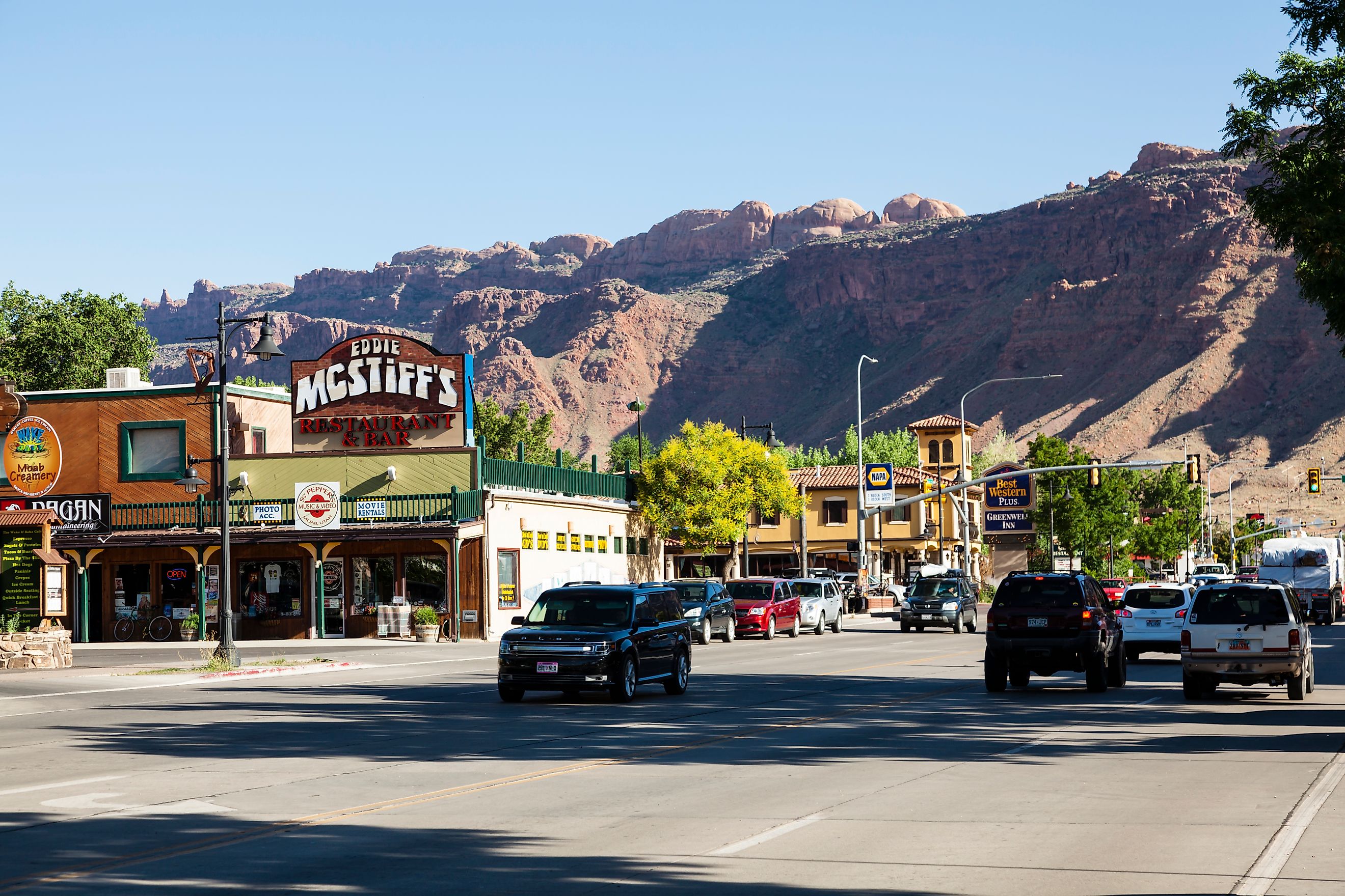 Store fronts, restaurant sign and street traffic at Main Street in Moab - Utah, popular destination for rock climbers and bikers, getaway to Arches National Park.