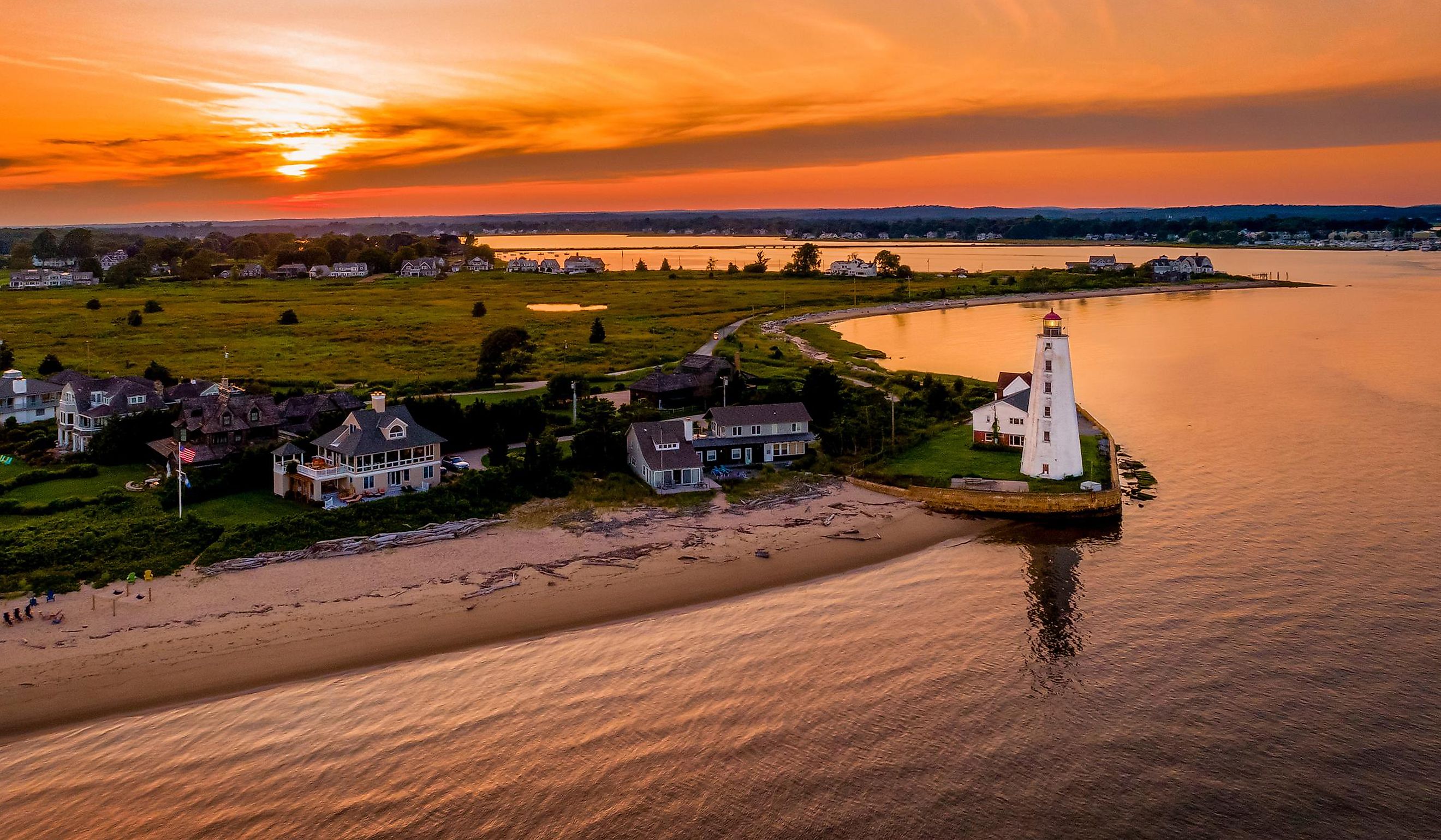 Summer sunset in Old Saybrook along the Connecticut River with Lynde Lighthouse in the foreground and a summer sunset. By Gregory on Adobe Stock.