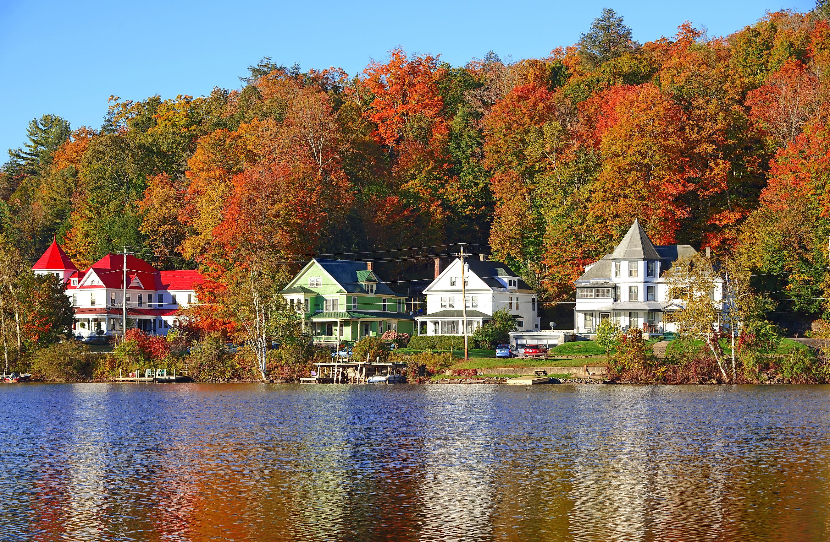 Waterfront homes and fall foliage along Saranac Lake in New York.