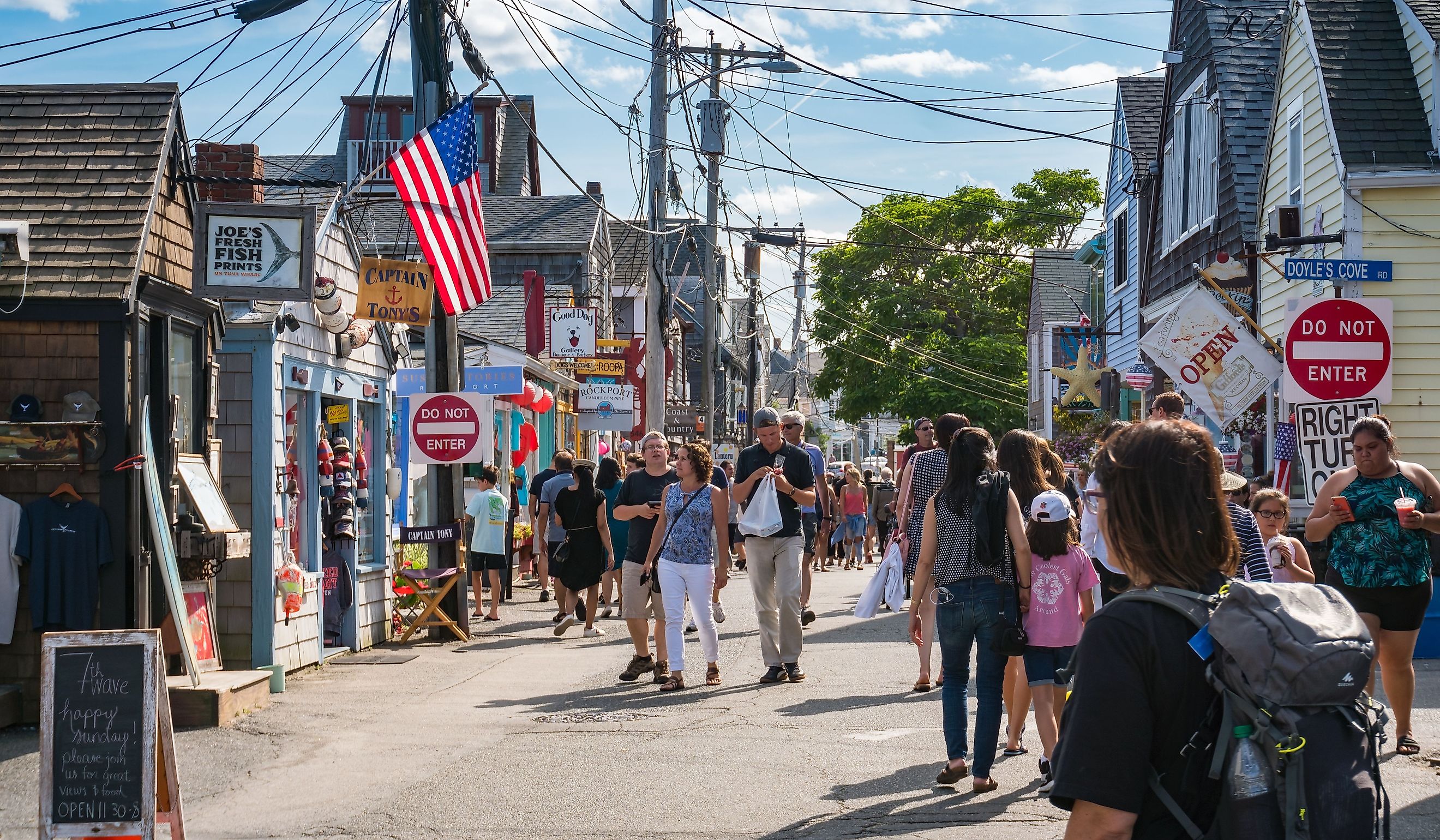 People and tourists stroll through the streets and numerous shops in Rockport, Massachusetts during a sunny day. Editorial credit: starmaro / Shutterstock.com