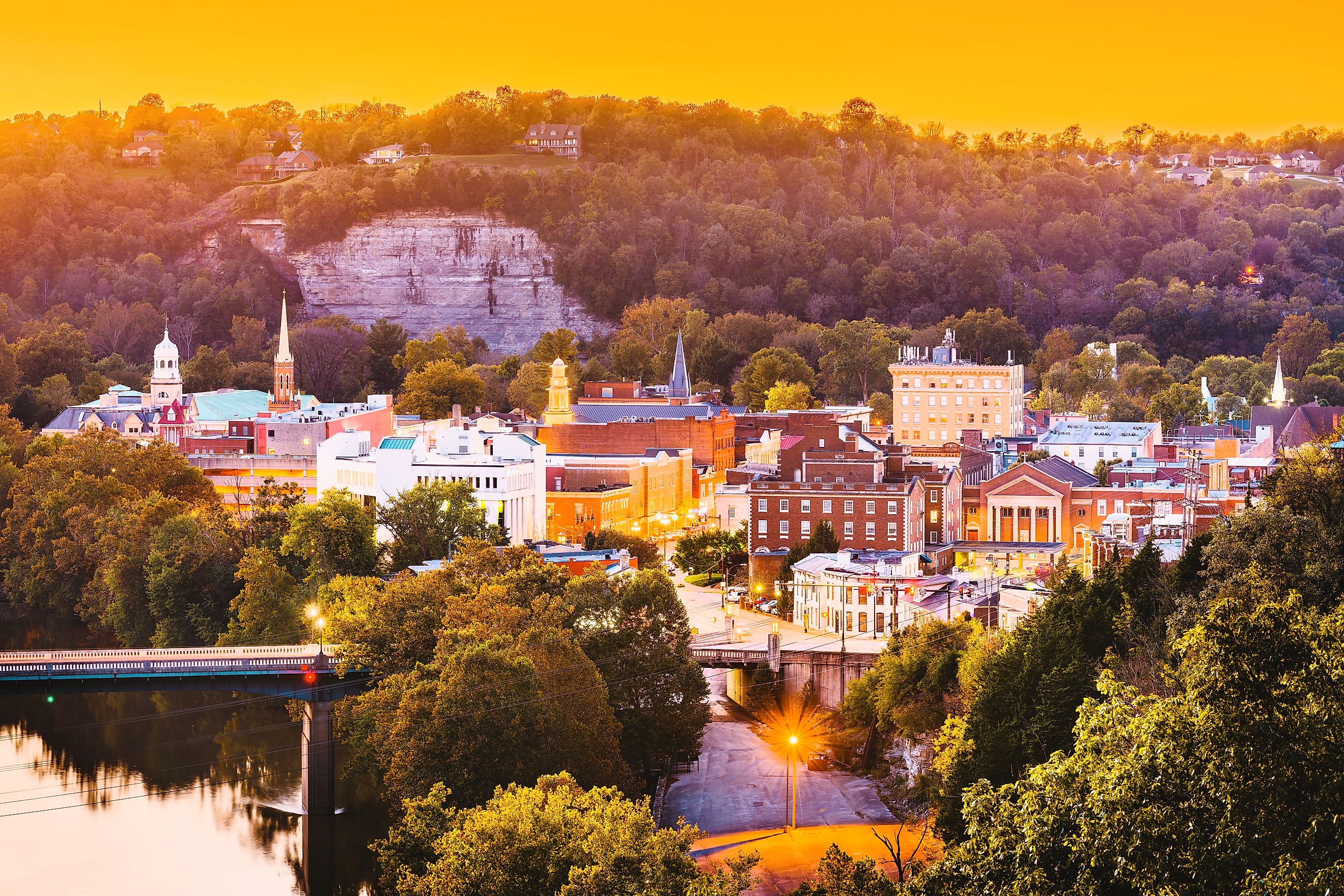 The town skyline of Frankfort, Kentucky, at dusk, with the Kentucky River winding through the scene.