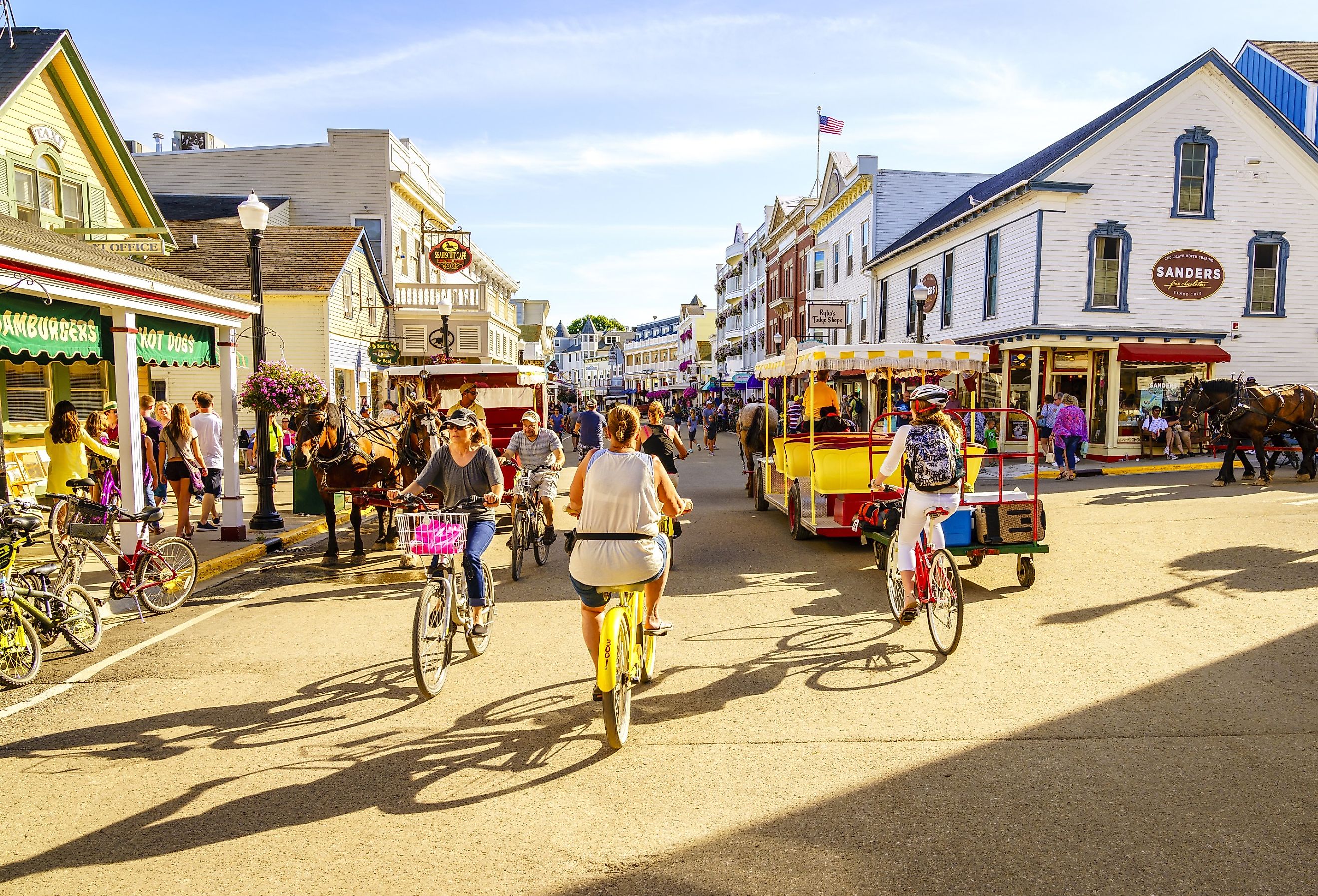 Vacationers ride bicycles along Market Street on Mackinac Island, Michigan. Image credit Alexey Stiop via Shutterstock