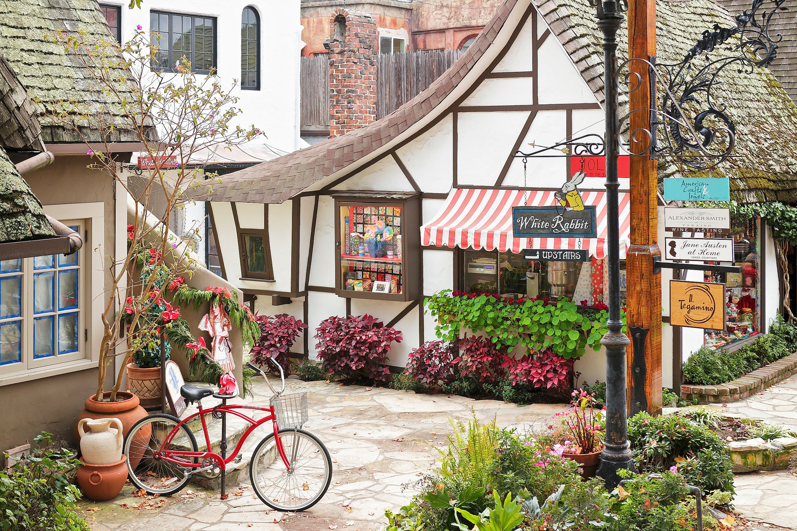 A streetscape in Carmel-by-the-Sea featuring a retail shop housed in a typical fairytale cottage - style architecture. Carmel located on the Monterey Peninsula was founded in 1902 and is known for its natural scenery and artistic history, via S. Greg Pano