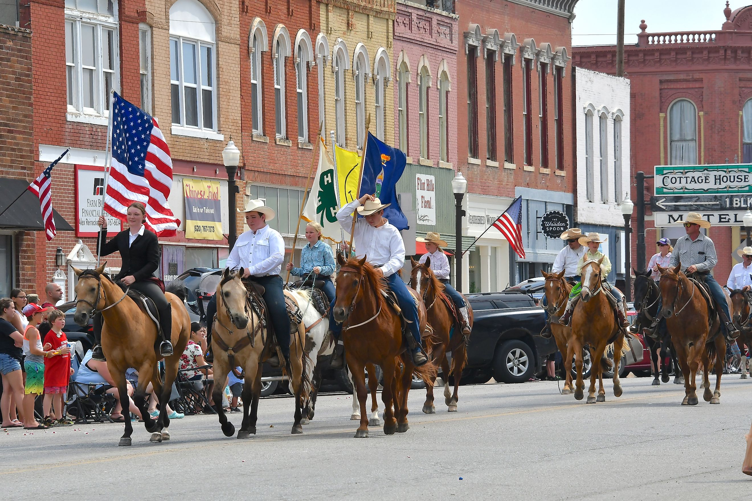 Members of the Local 4-H club riding their horses on Main Street during the Washunga Days Parade in Council Grove, Kansas, USA. Editorial credit: mark reinstein / Shutterstock.com