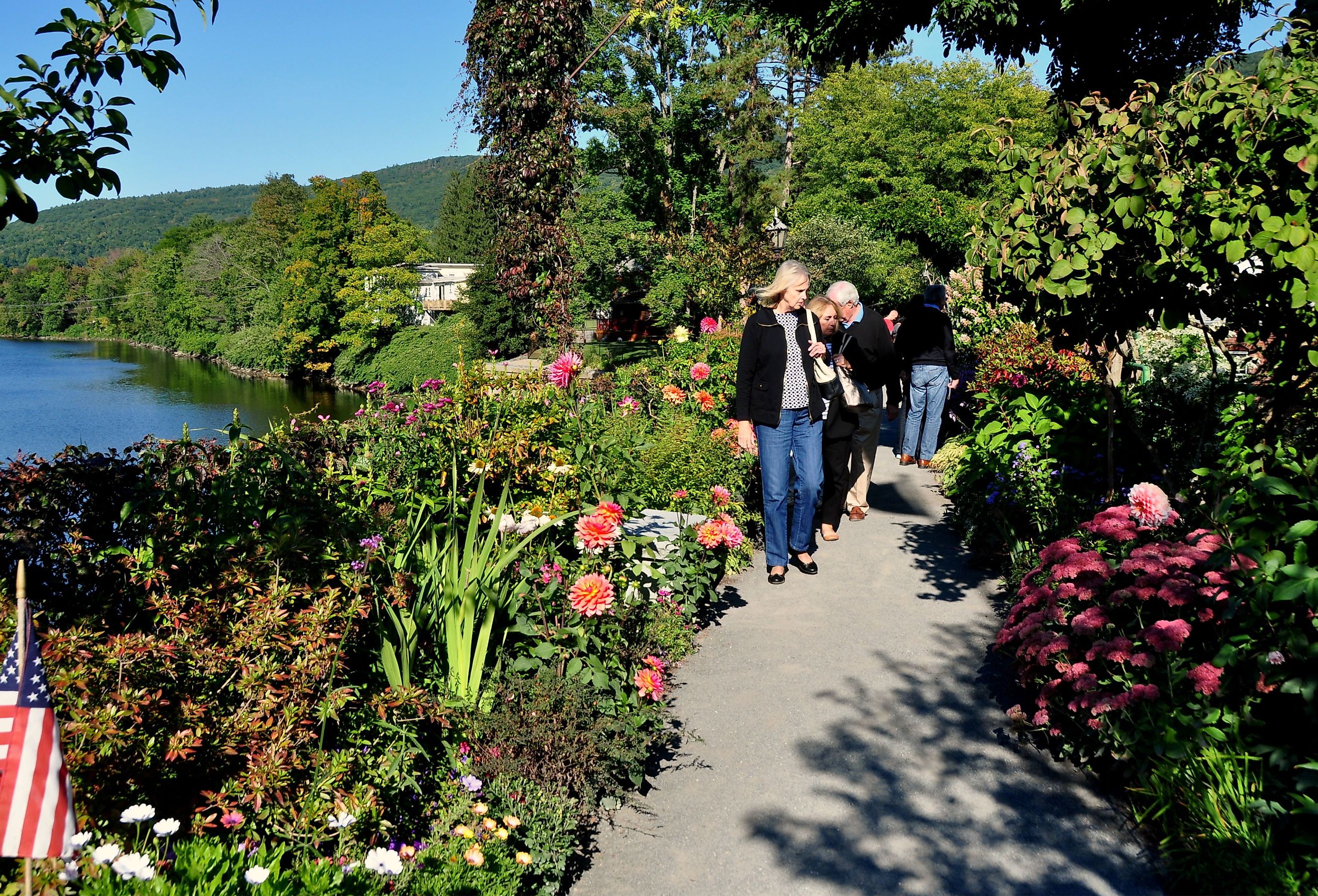 Visitors strolling along the former trolley span now the Bridge of Flowers over the Deerfield River in Shelburne Falls. Image credit LEE SNIDER PHOTO IMAGES via Shutterstock.