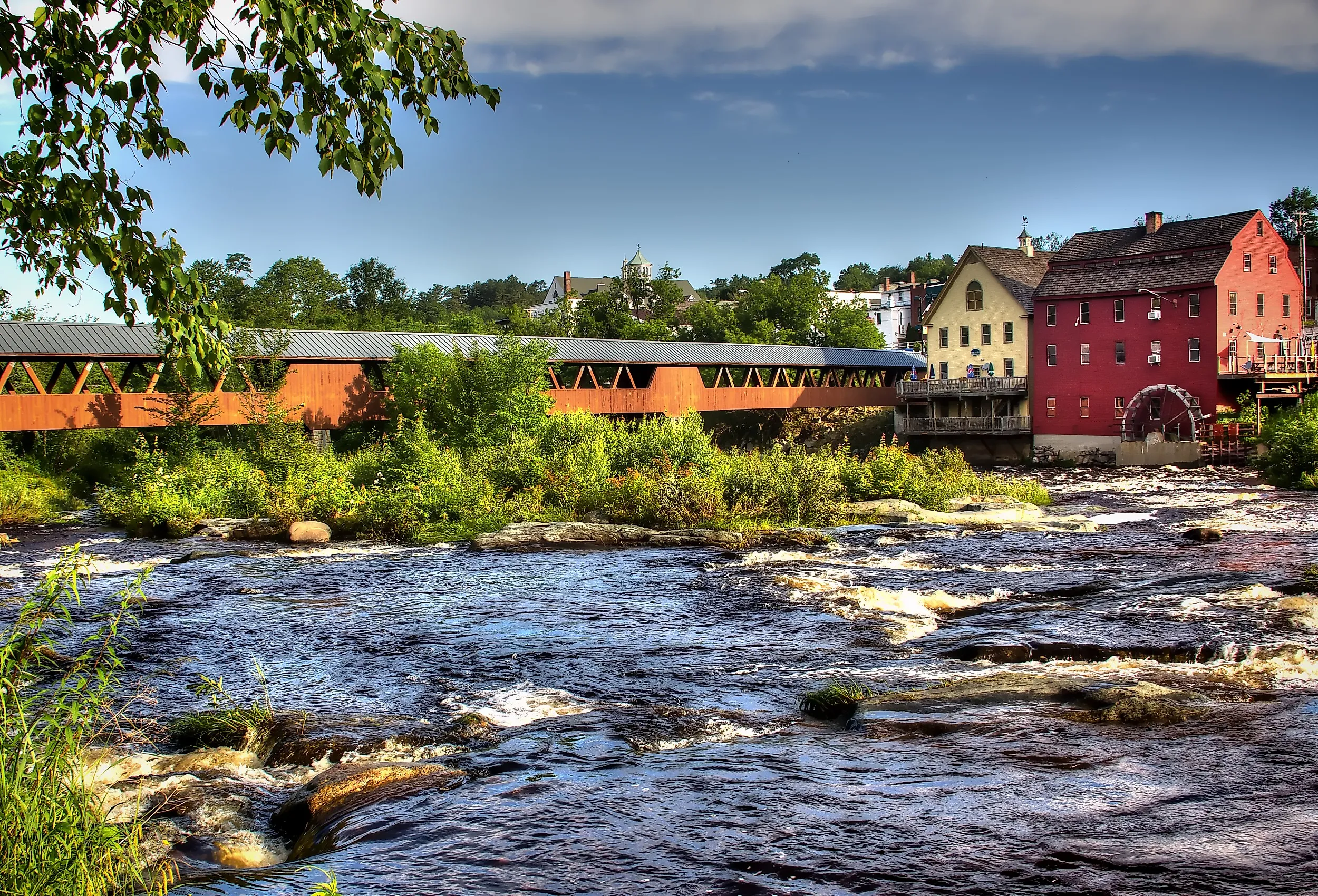 The River Walk Covered Bridge with the Grist mill on the Ammnosuoc River in Littleton, New Hampshire.