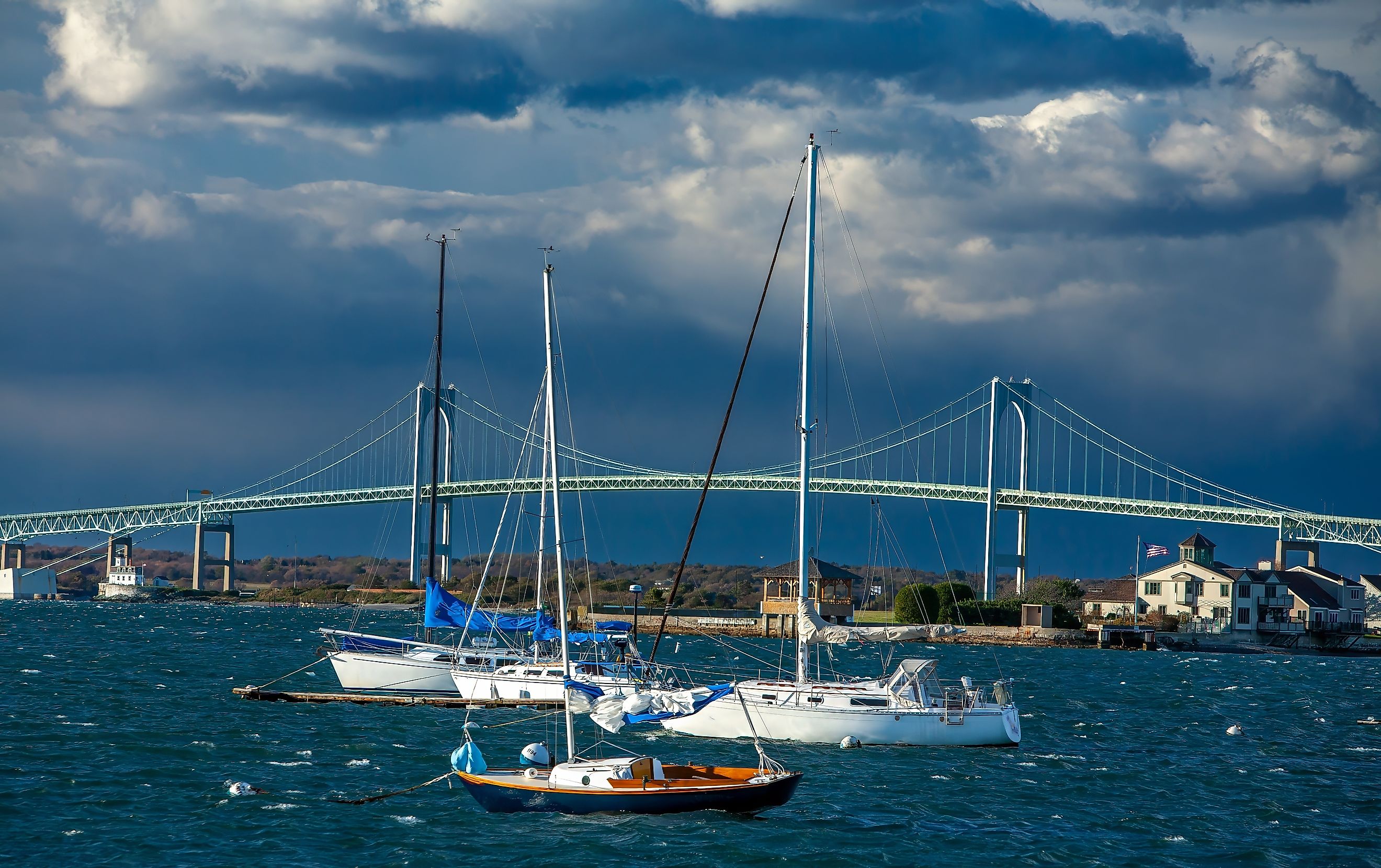 Sailboats and pleasure crafts are docked within sight of the Newport Pell bridge, connecting Jamestown and Newport, Rhode Island