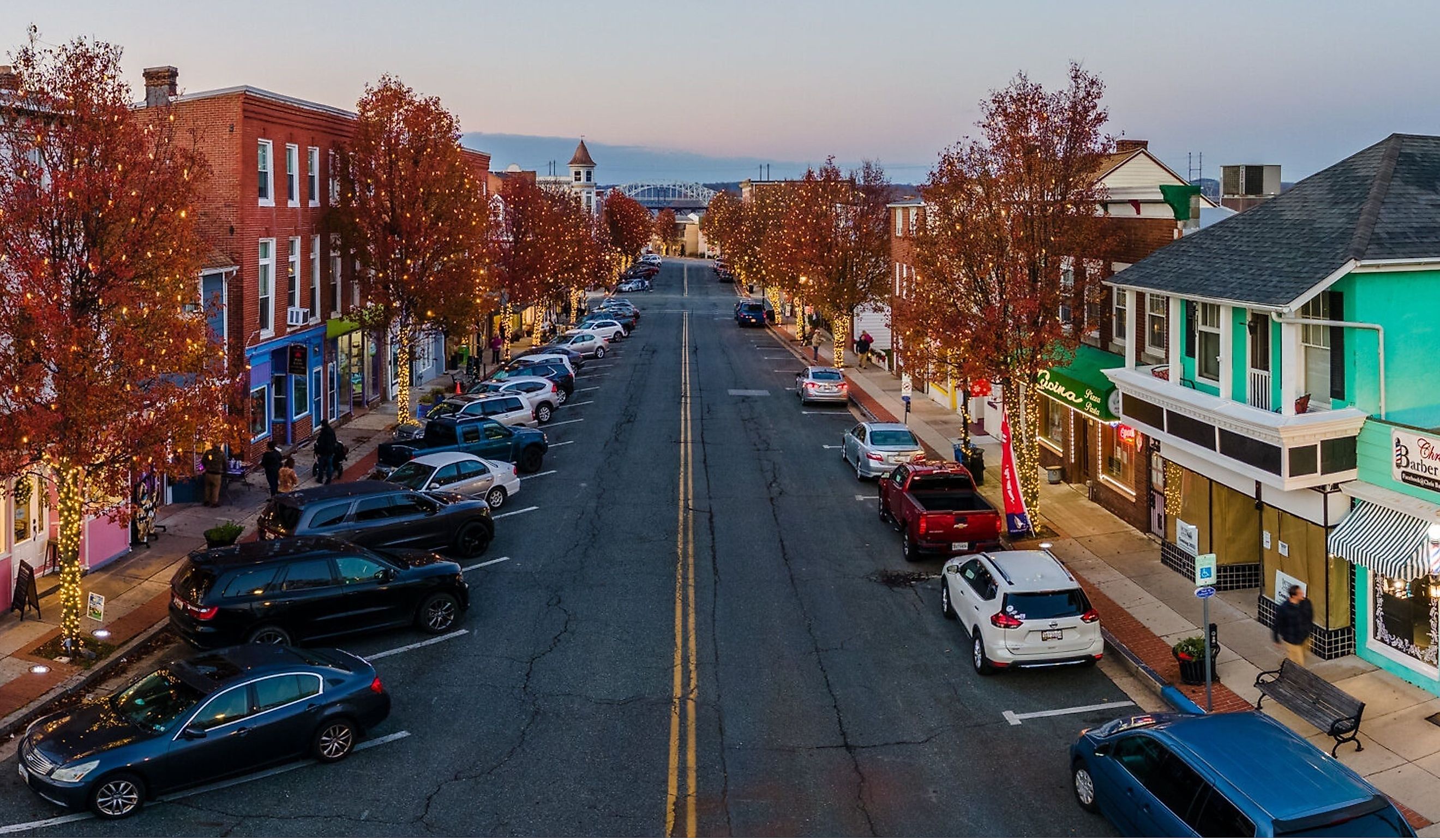An empty street in Havre De Grace city illuminated by the golden light of dusk, with parked cars lining the sides of the road. Editorial credit: Wirestock Creators / Shutterstock.com