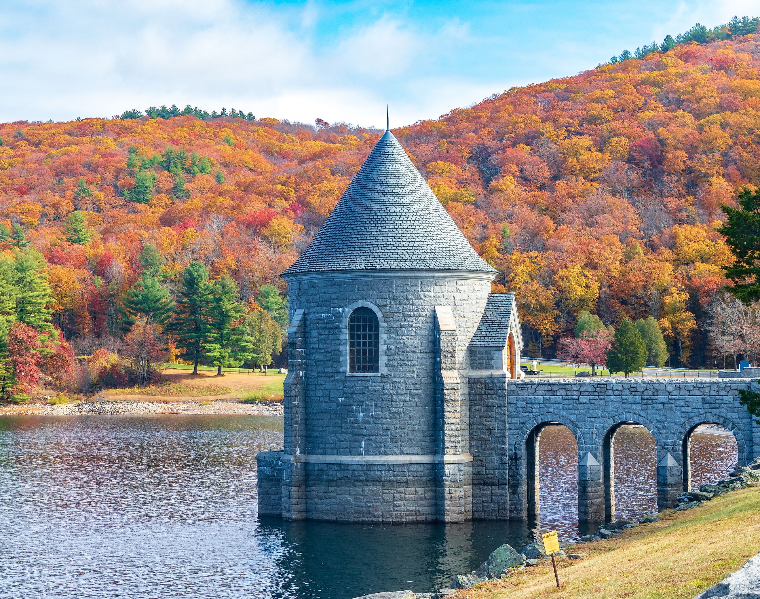 Saville Dam with colorful trees covering hills in the background, Barkhamsted, Connecticut.