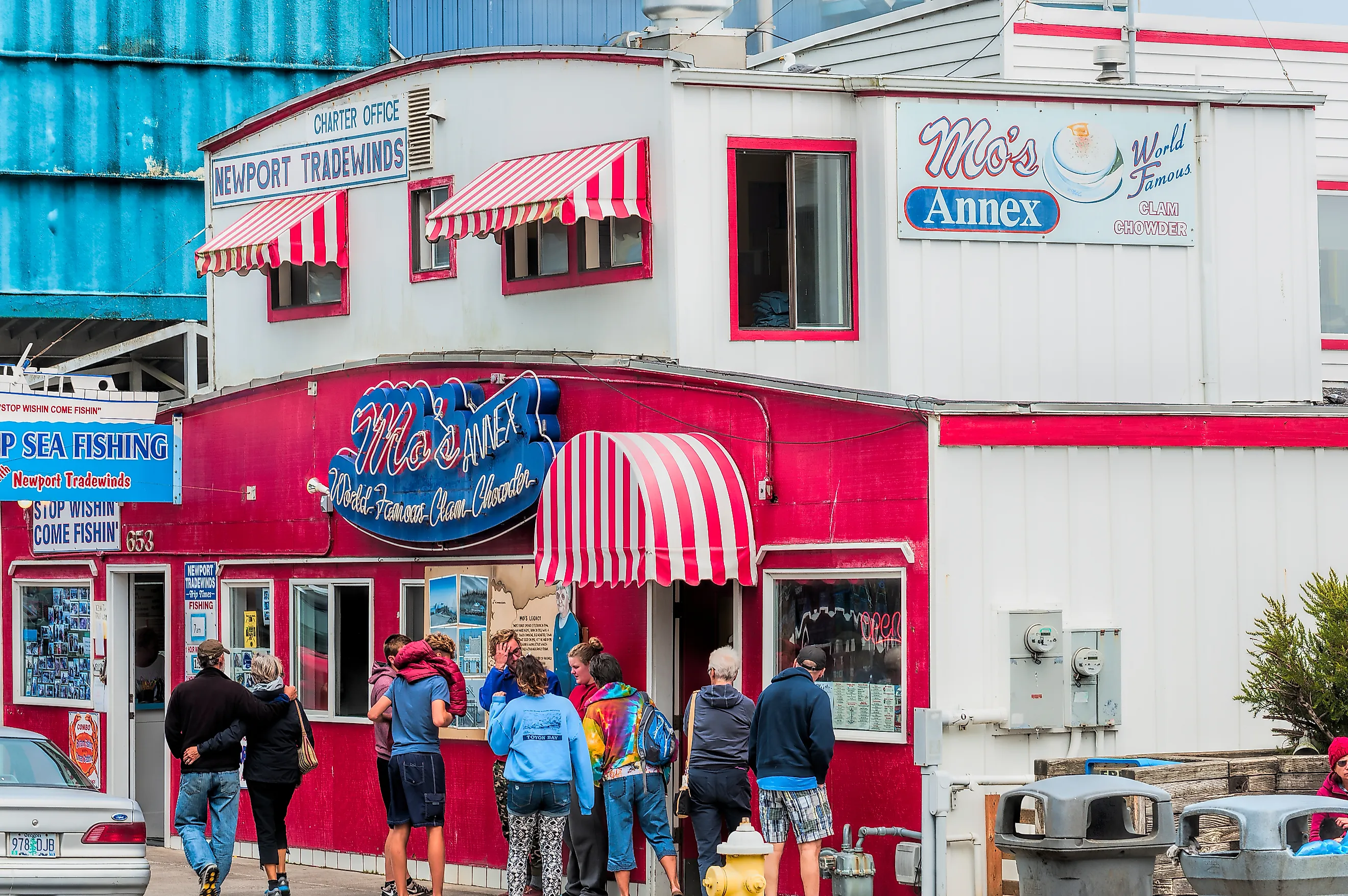 Dee Browning via Shutterstock. Newport, Oregon,USA - August 23, 2015: Tourist stand in front of Moe's seafood annex in downtown Newport.