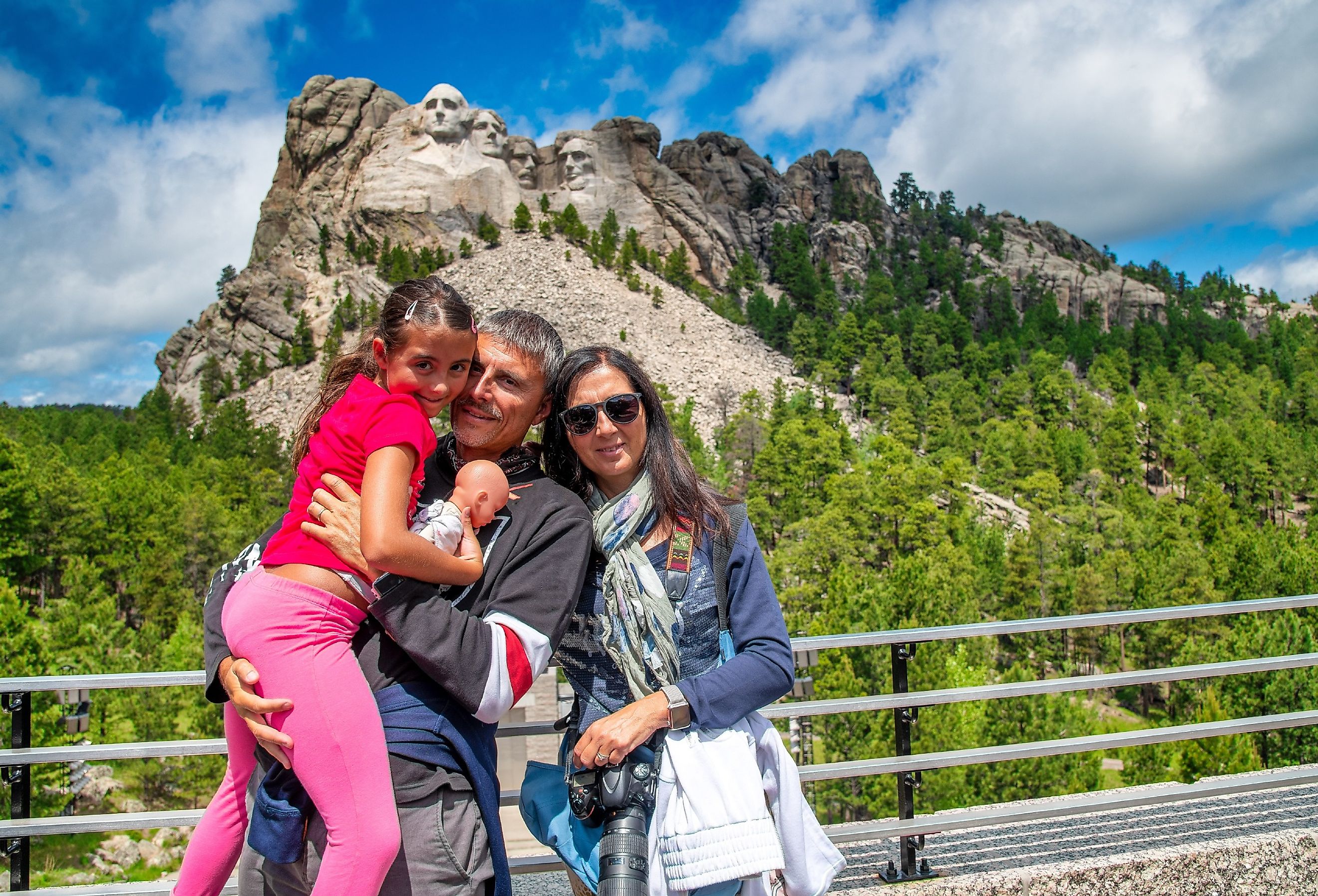 Happy family visiting Mt Rushmore tourist attraction in South Dakota.