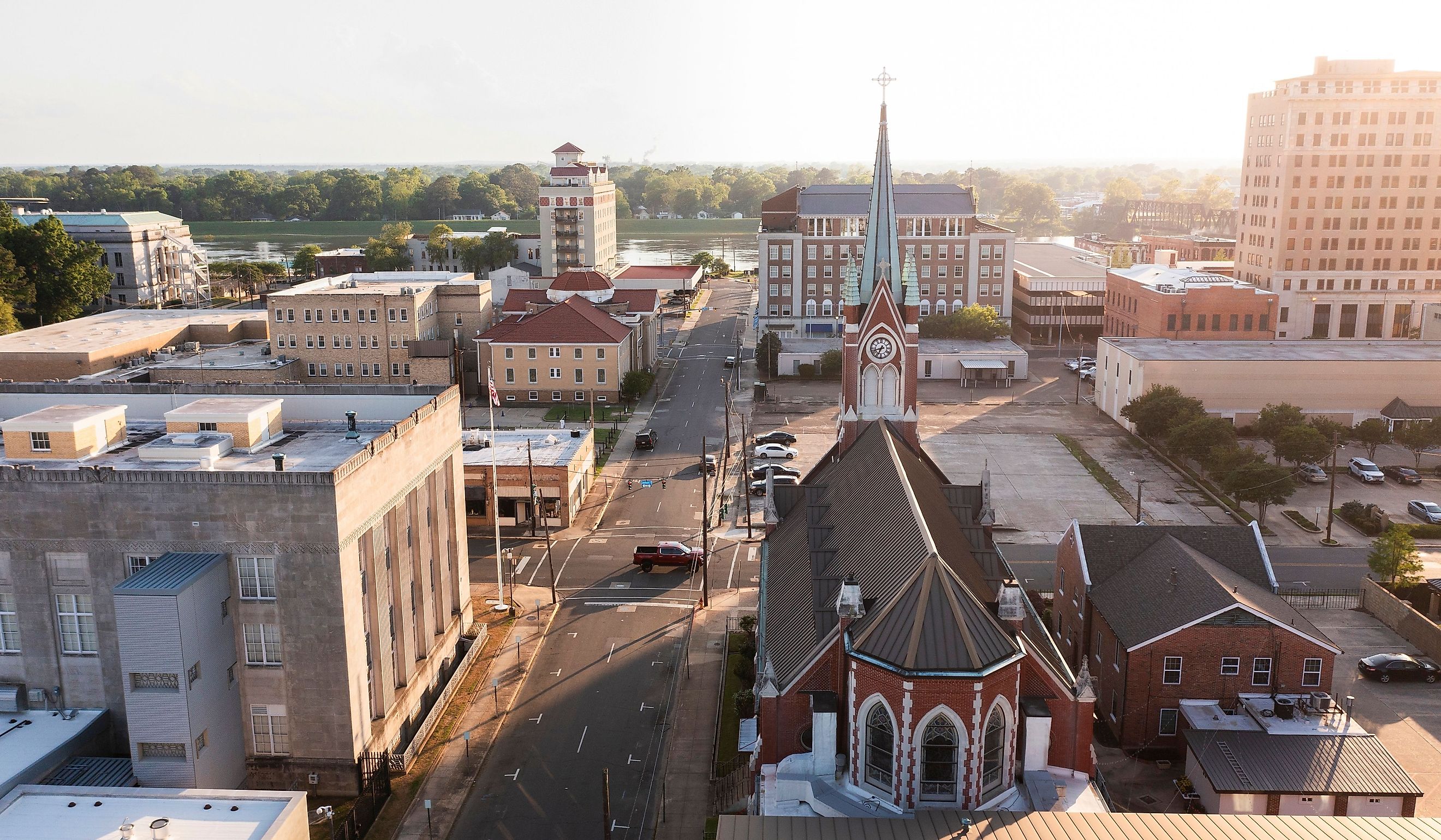 Afternoon sunlight shines on the historic buildings and church in the skyline of downtown Monroe.