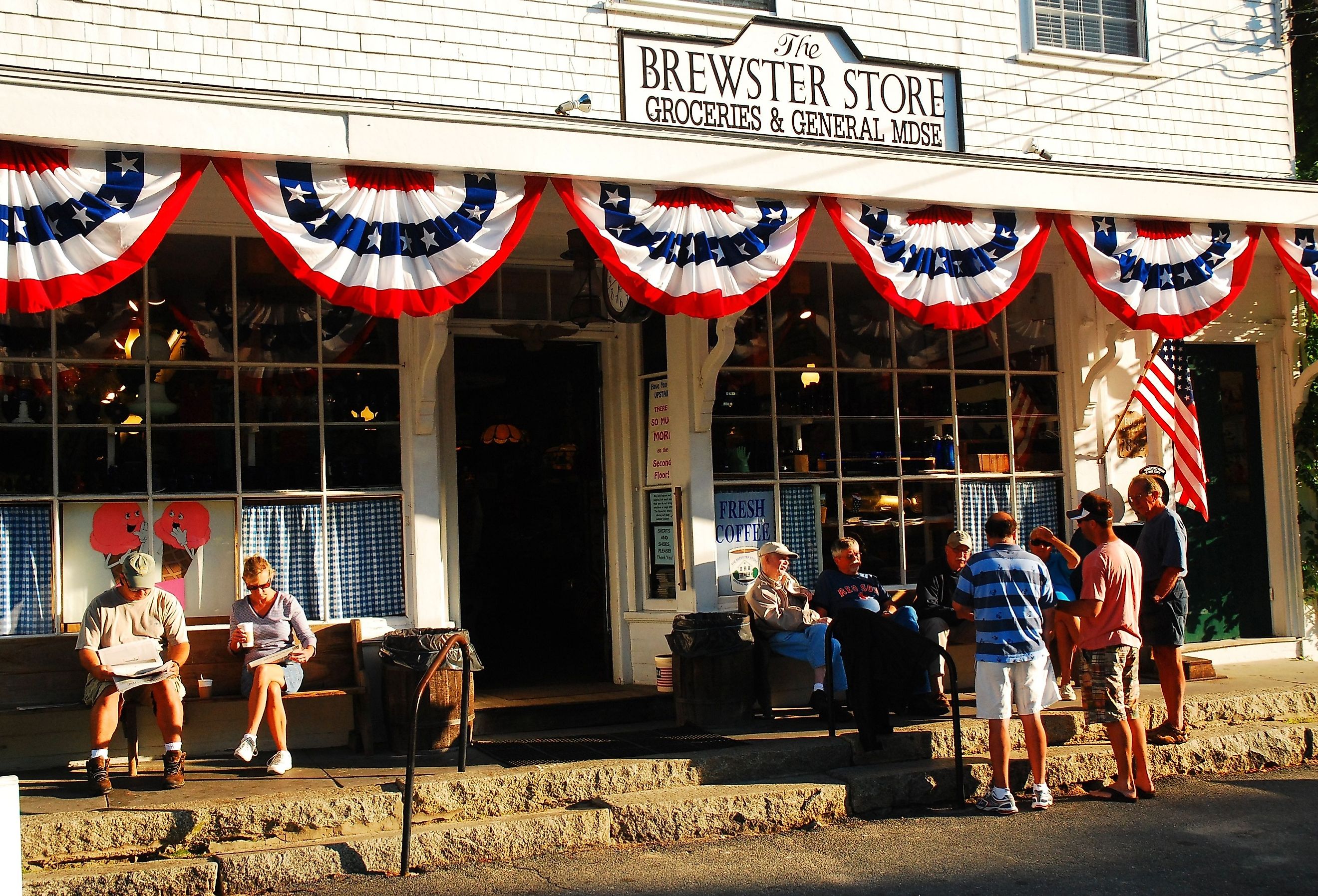 People gather and talk to friends in front of the general store in Brewster, Massachusetts. Image credit James Kirkikis via Shutterstock.