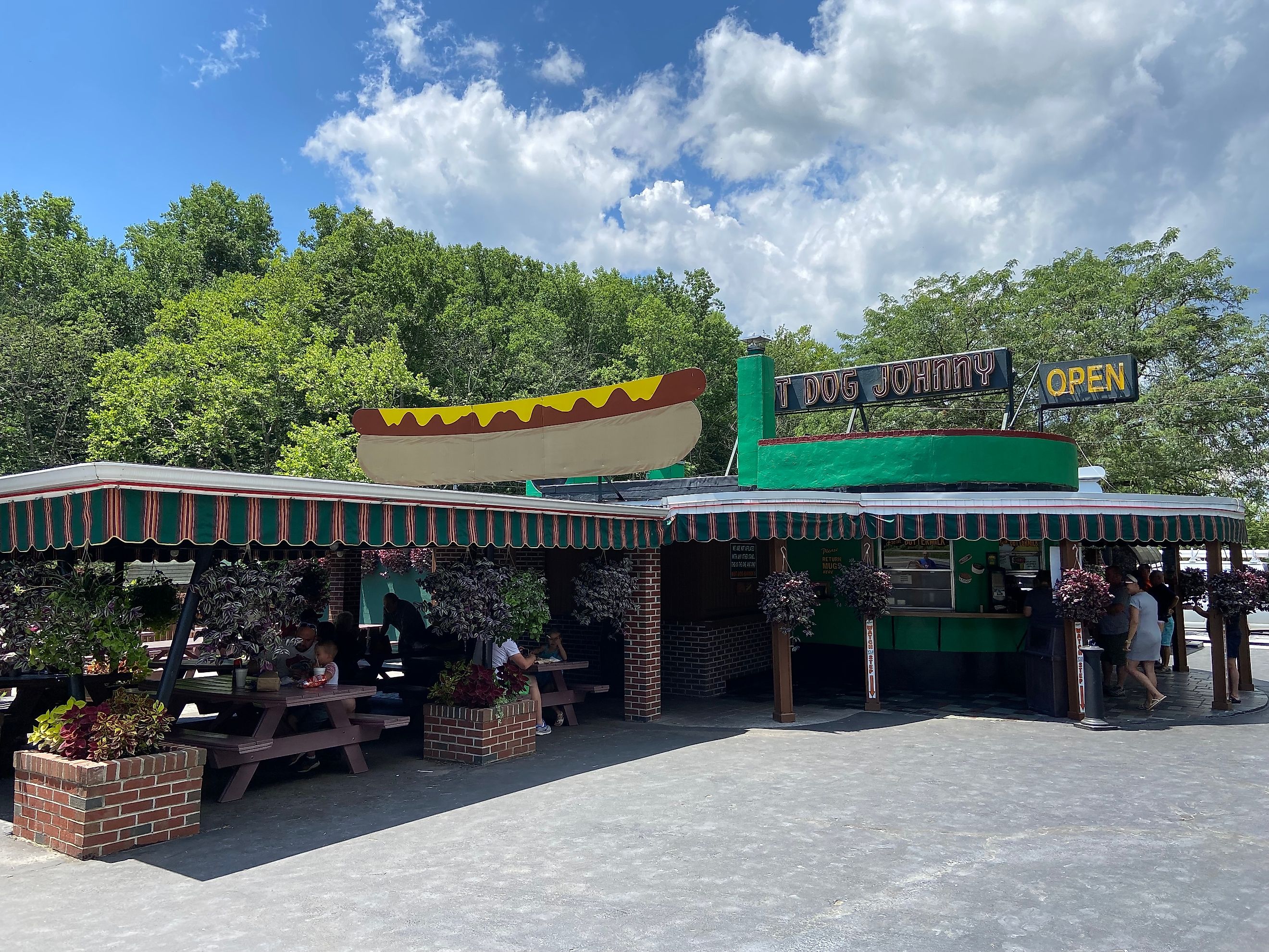 Vintage illustrated and neon signs on the roof of Hot Dog Johnny's roadside stand open on a sunny summer day in New Jersey. Editorial credit: Here Now / Shutterstock.com