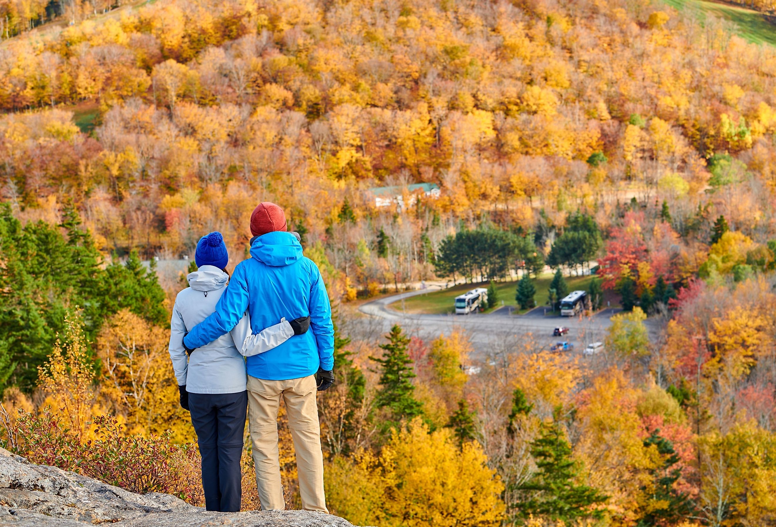 Couple hiking at Artist's Bluff in autumn. Fall colours in Franconia Notch State Park. White Mountain National Forest, New Hampshire, USA