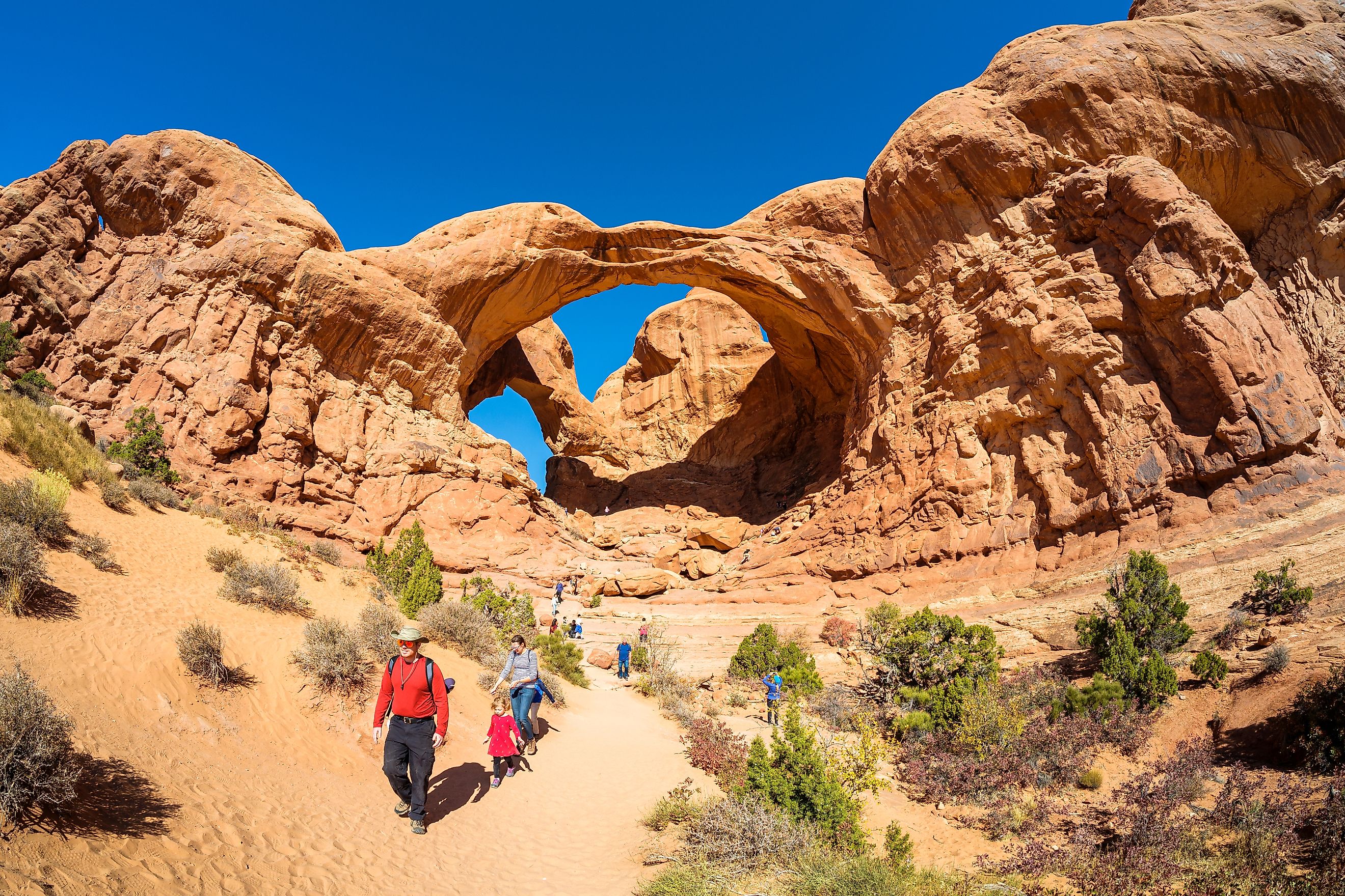 A family of adventurers in Double Arch in Arches National Park, Moab, Utah. Photography by Fotoluminate LLC via Shutterstock 